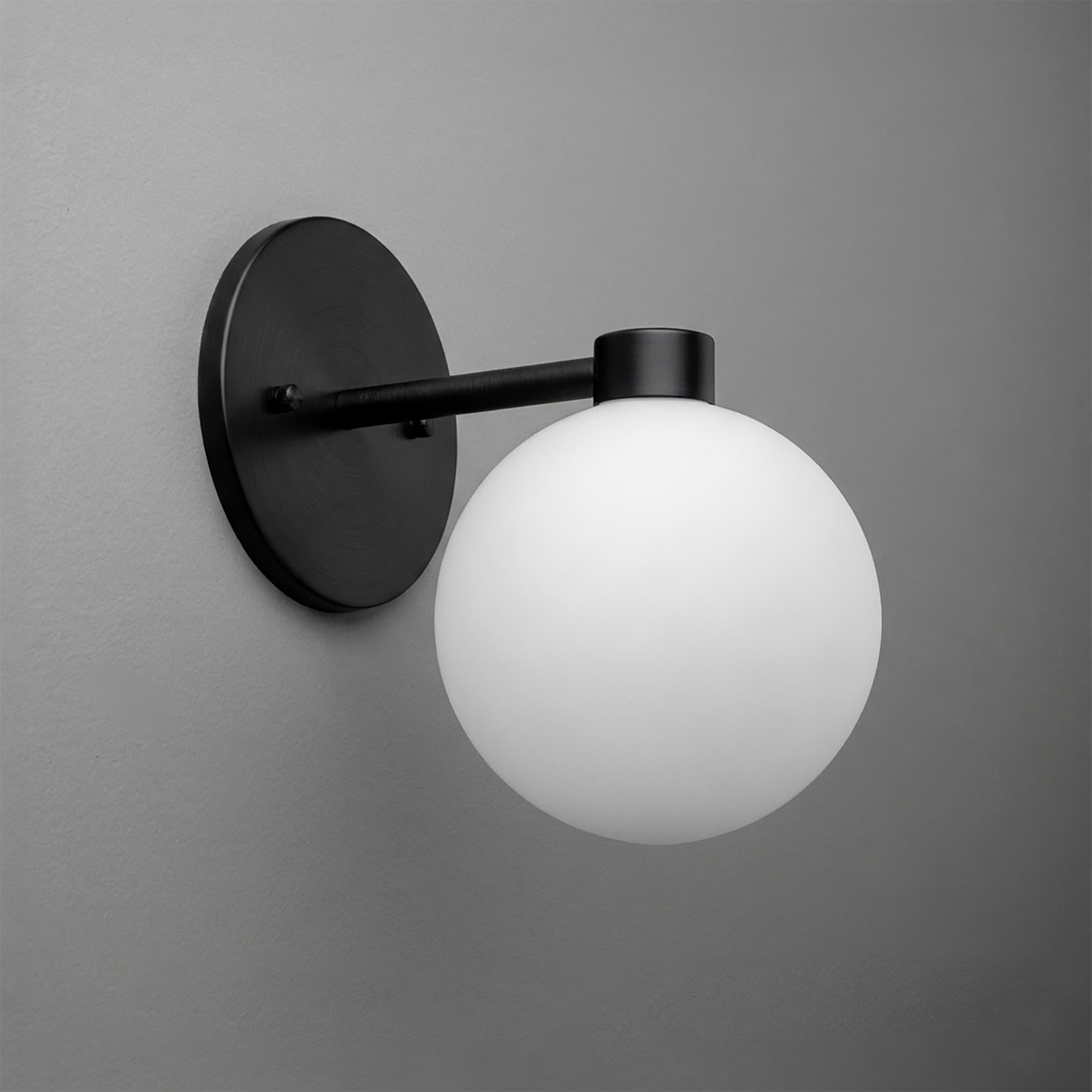 Matte black metal wall sconce with a single frosted white glass globe shade. - SCONCE MODEL NO. 2341