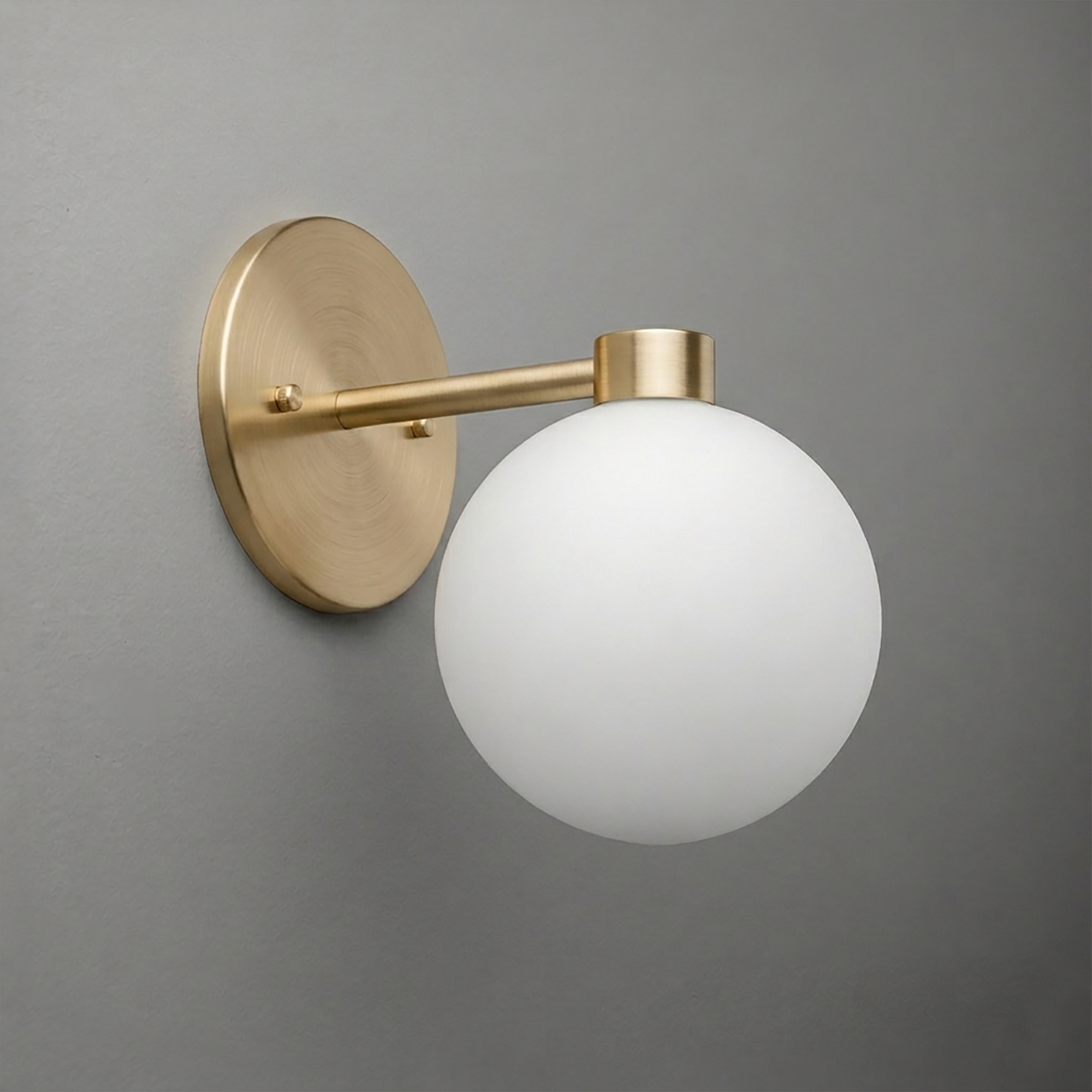 Wall sconce with a brushed brass round base and arm holding a frosted white glass globe shade. - SCONCE MODEL NO. 2341
