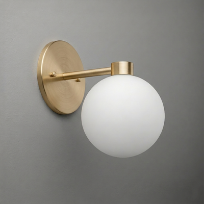 Wall sconce with a brushed brass round base and arm holding a frosted white glass globe shade. - SCONCE MODEL NO. 2341