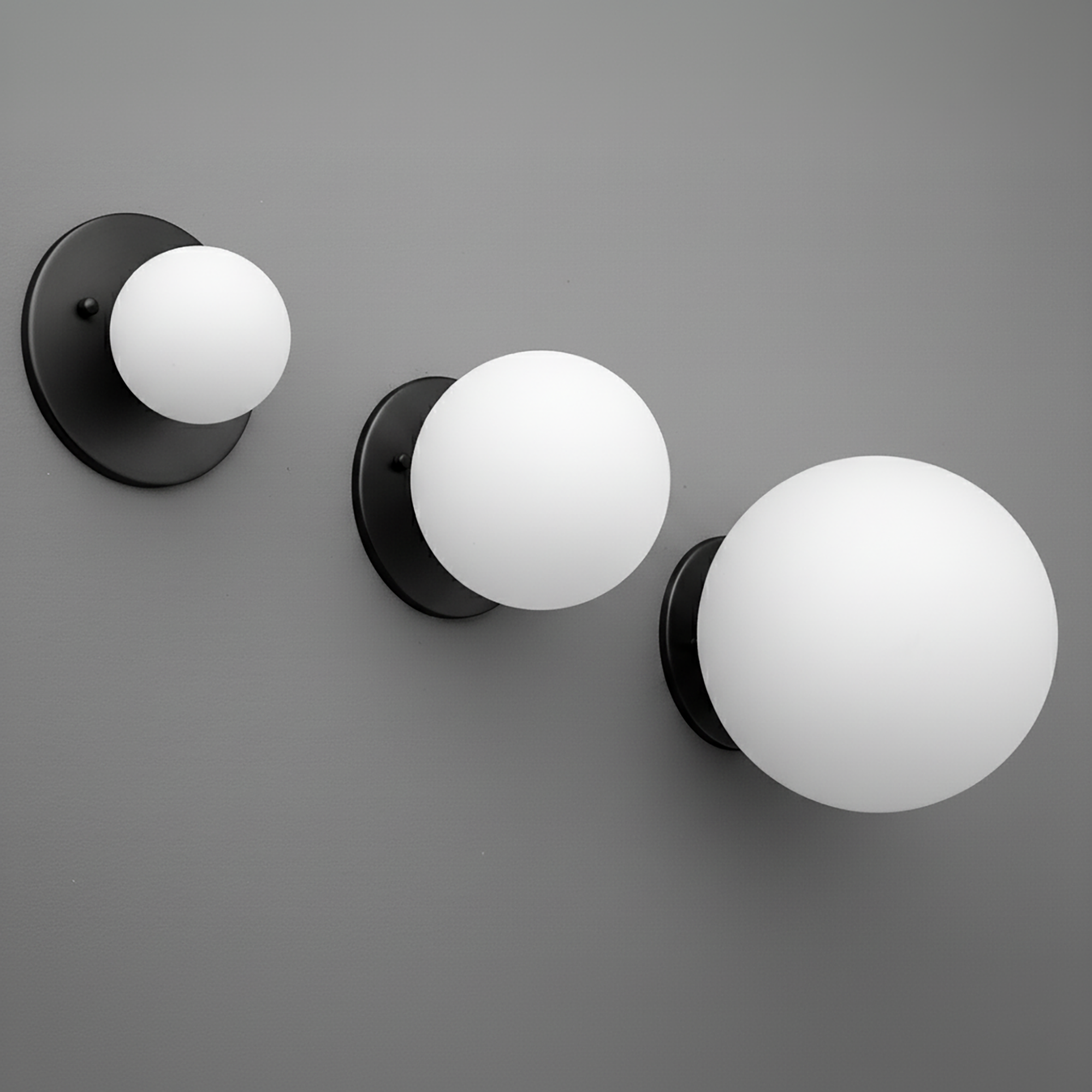 Set of three black wall sconces with frosted white glass globes in small, medium, and large sizes. - Sconce Model No. 5206