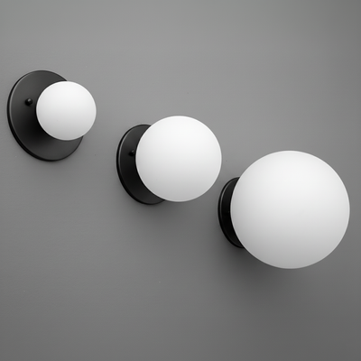 Set of three black wall sconces with frosted white glass globes in small, medium, and large sizes. - Sconce Model No. 5206