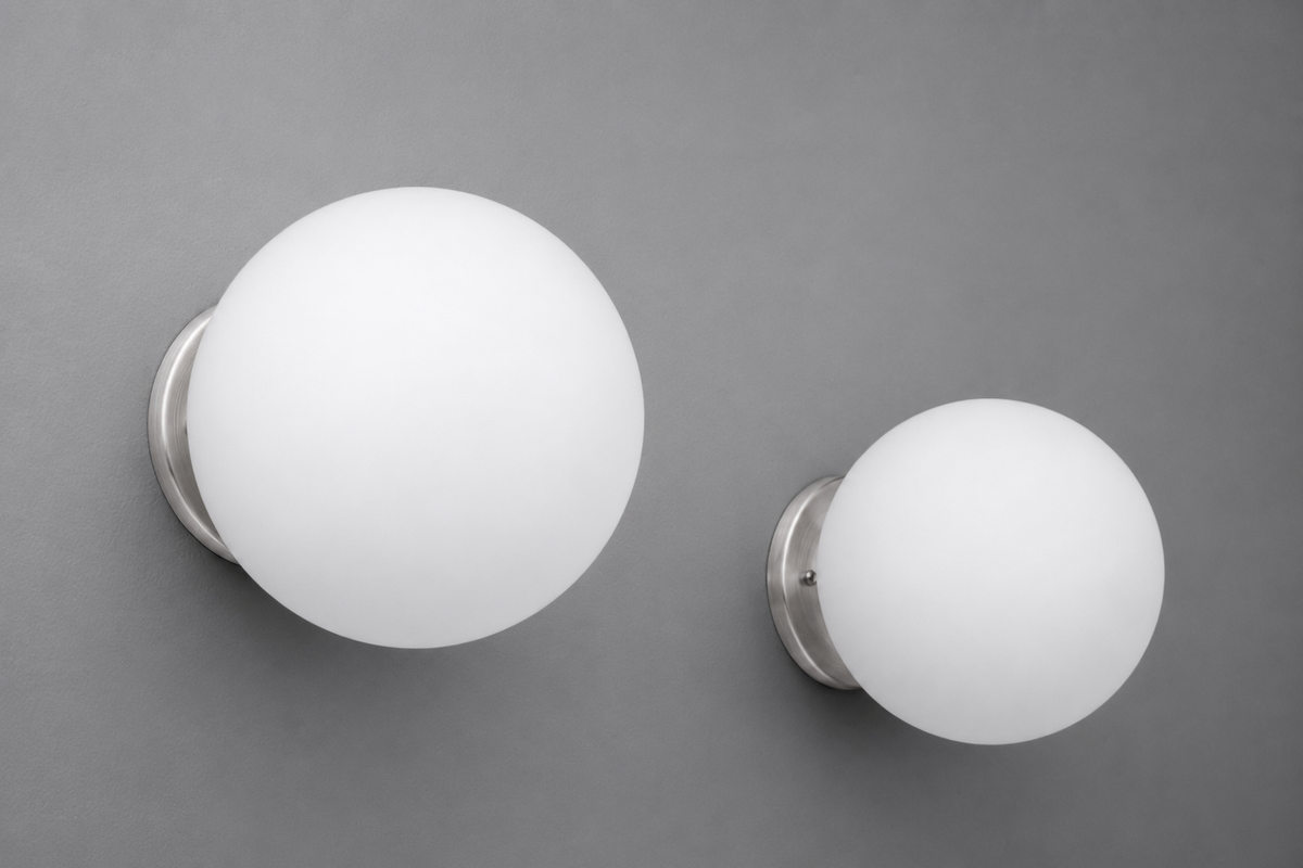 Two white frosted glass globe wall sconces with brushed nickel bases mounted on a gray wall. - Sconce Model No. 5206