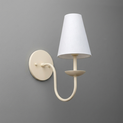 Cream-colored metal wall sconce with curved arm and white tapered fabric shade. - SCONCE MODEL NO. 7085