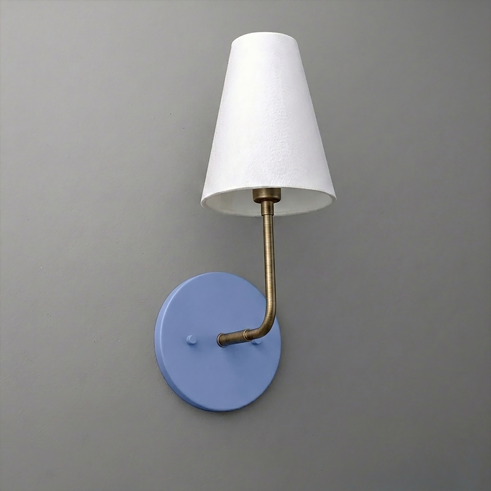 Single-bulb wall sconce with round blue base, brass arm, and white tapered fabric shade. - SCONCE MODEL NO. 3928