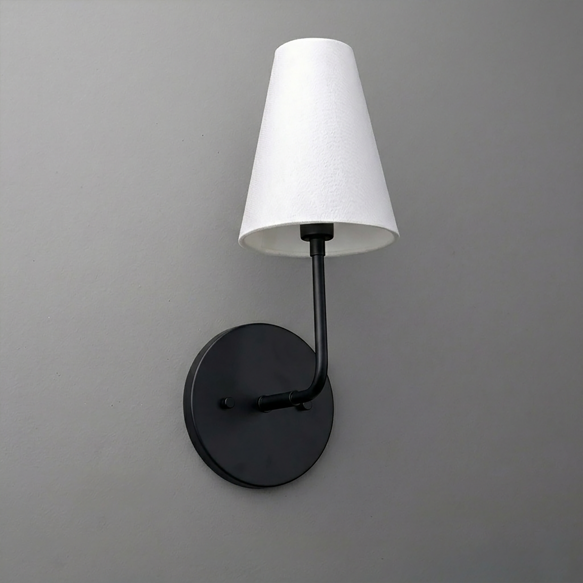 Black metal sconce with a round base and white tapered fabric shade. - SCONCE MODEL NO. 3928