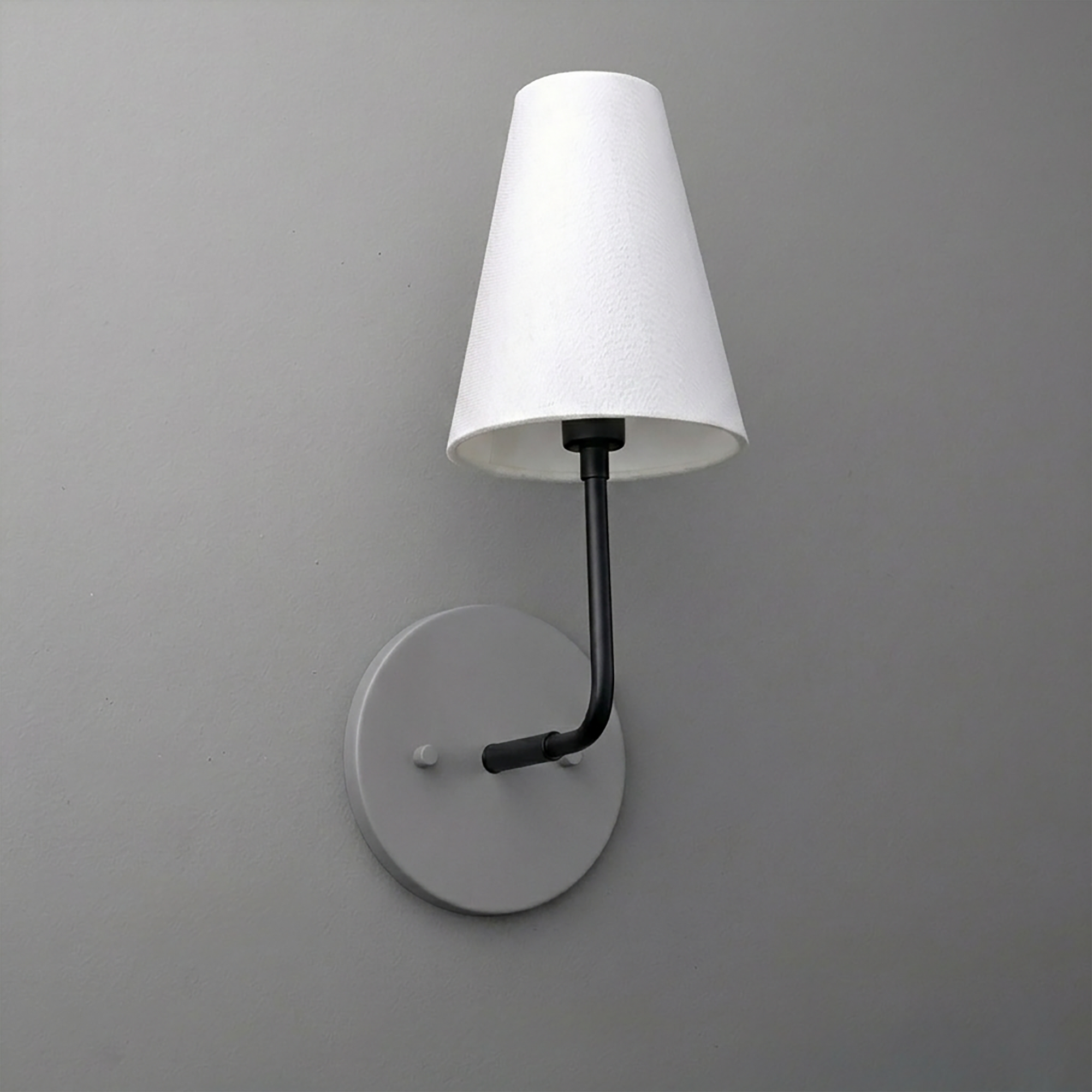 Black metal wall sconce with round base and white tapered fabric shade. - SCONCE MODEL NO. 3928