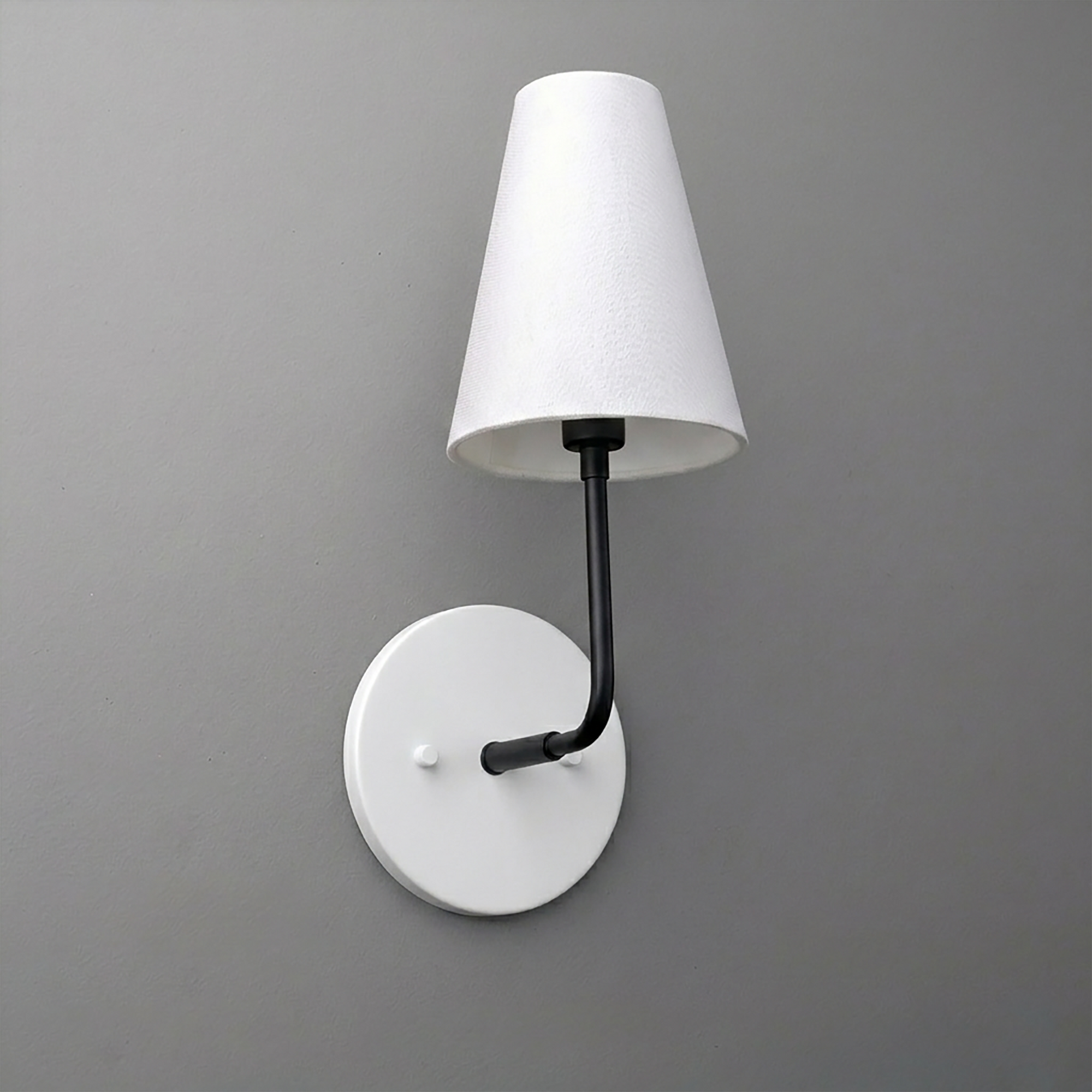 Black metal 1-bulb wall sconce with white tapered fabric shade and round white base. - SCONCE MODEL NO. 3928