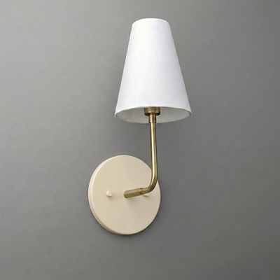 Wall sconce with round beige metal base, brass arm, and white tapered fabric lampshade. - SCONCE MODEL NO. 3928