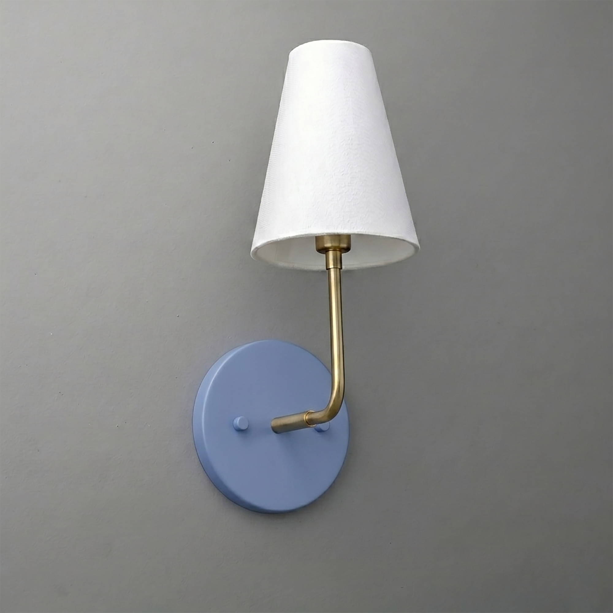 Wall-mounted sconce with round blue base, brass arm, and white tapered fabric shade. - SCONCE MODEL NO. 3928