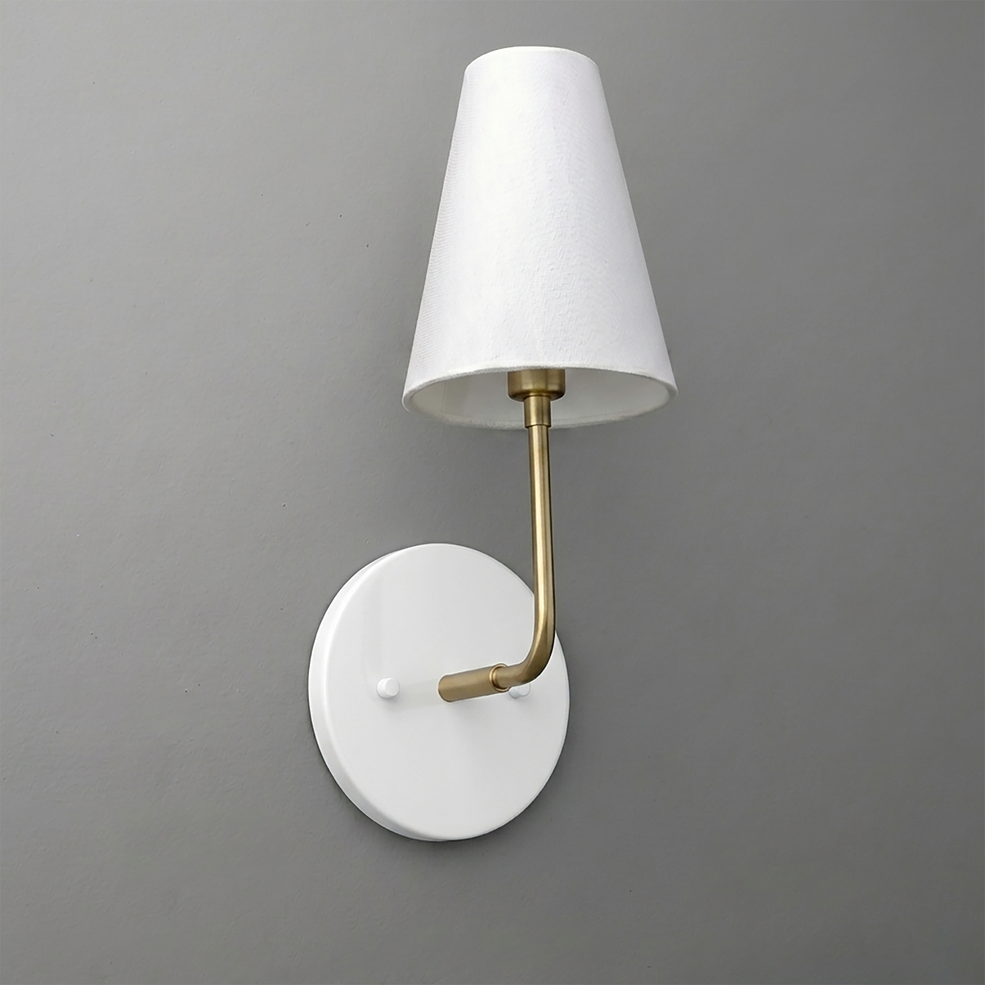 White round wall sconce with brass arm and tapered white fabric shade. - SCONCE MODEL NO. 3928