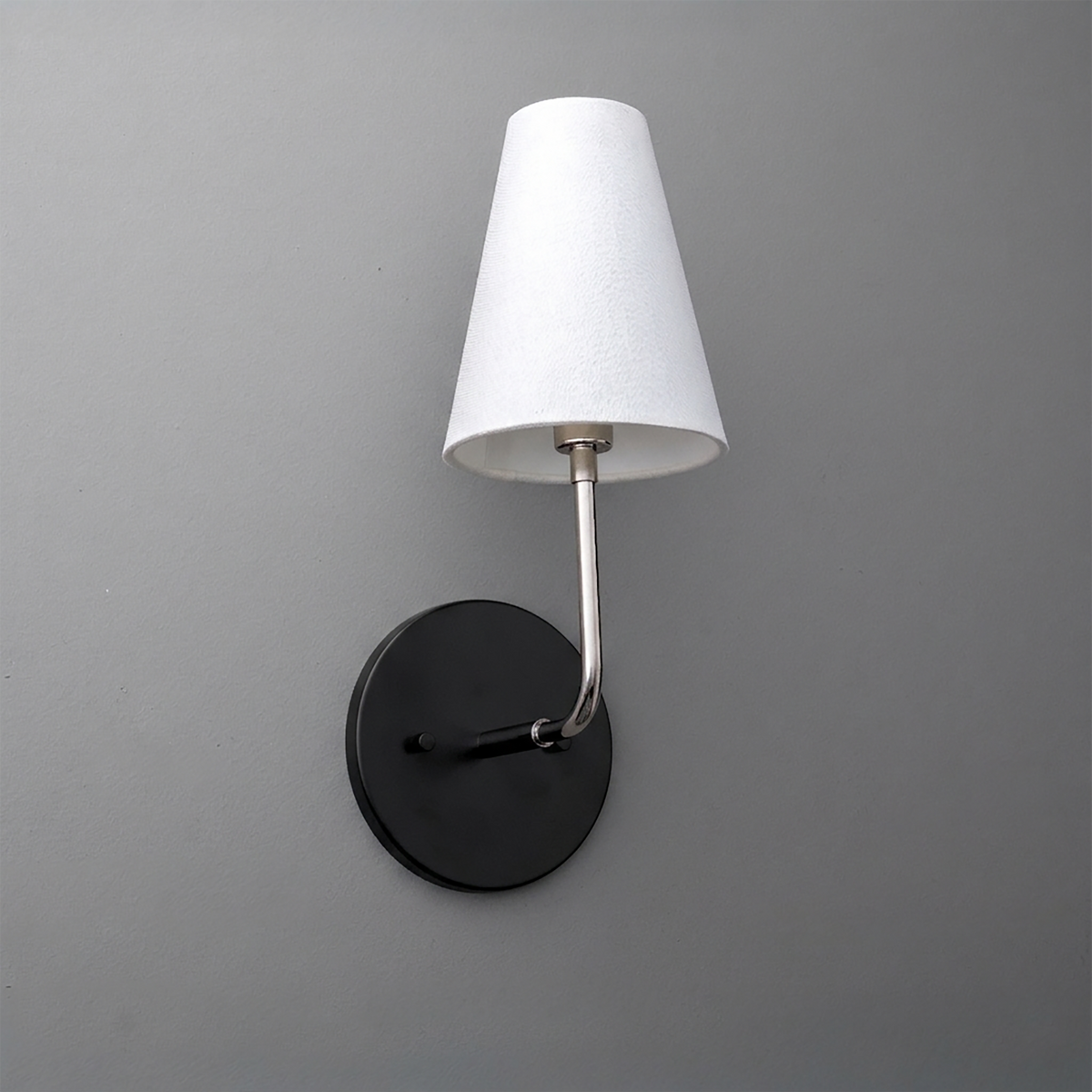 Wall-mounted sconce with black round base, brushed metal arm, and white tapered fabric shade. - SCONCE MODEL NO. 3928