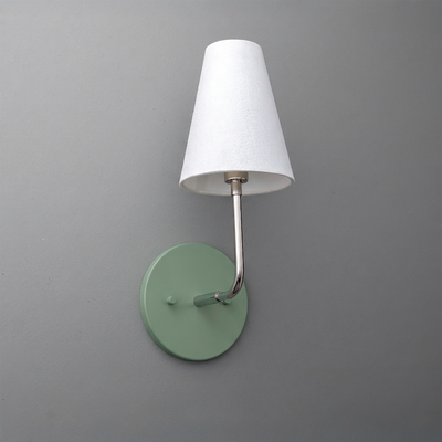 Wall-mounted sconce with round sage green metal base and slender silver arm holding a white tapered fabric shade. - SCONCE MODEL NO. 3928