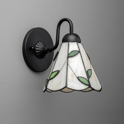 Black metal wall sconce with curved arm and floral stained glass shade featuring white, green, and beige tones. - SCONCE MODEL NO. 8543