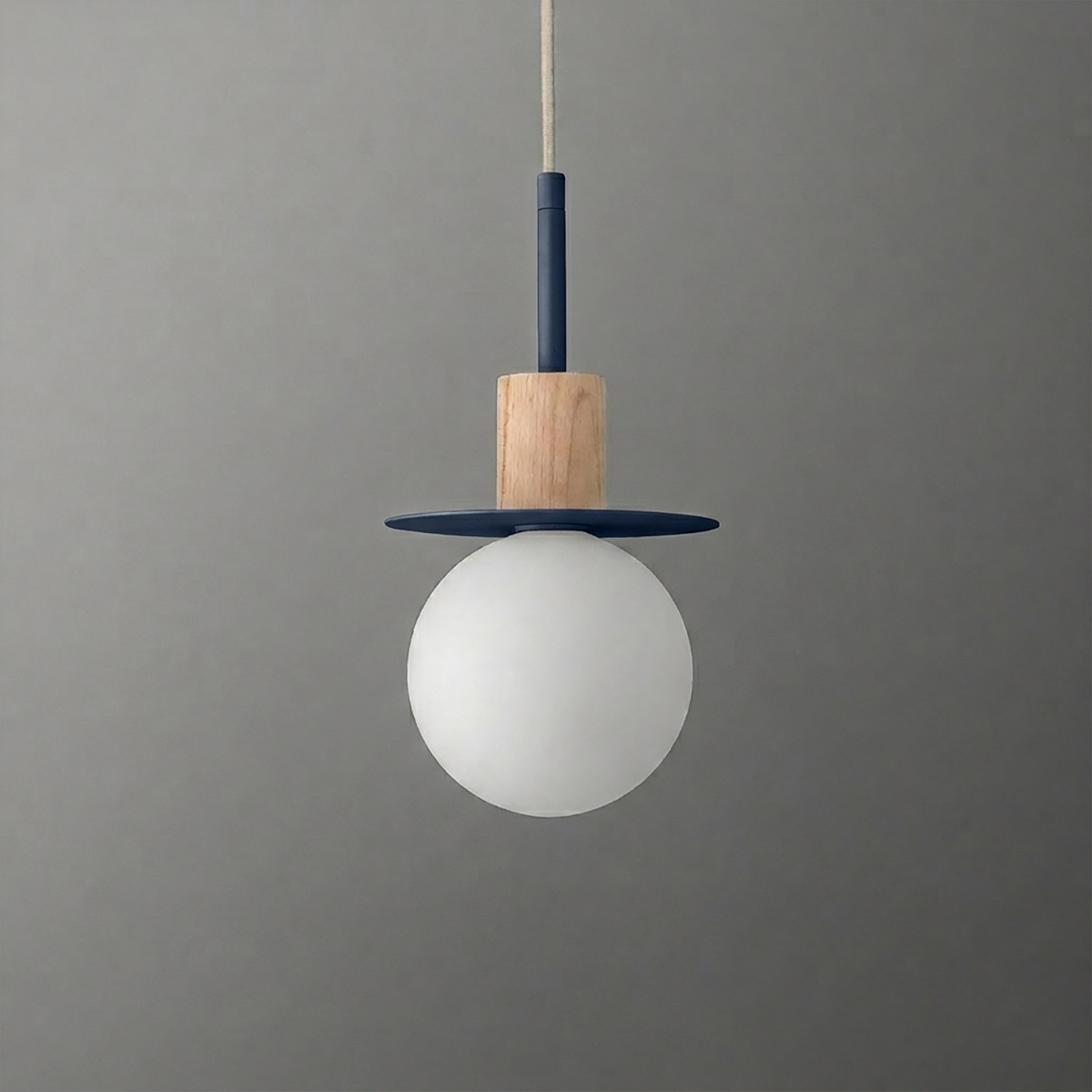 Pendant light with frosted white globe, wooden accent, and navy blue circular metal detail hanging from a beige cord. - PENDANT MODEL NO. 6198