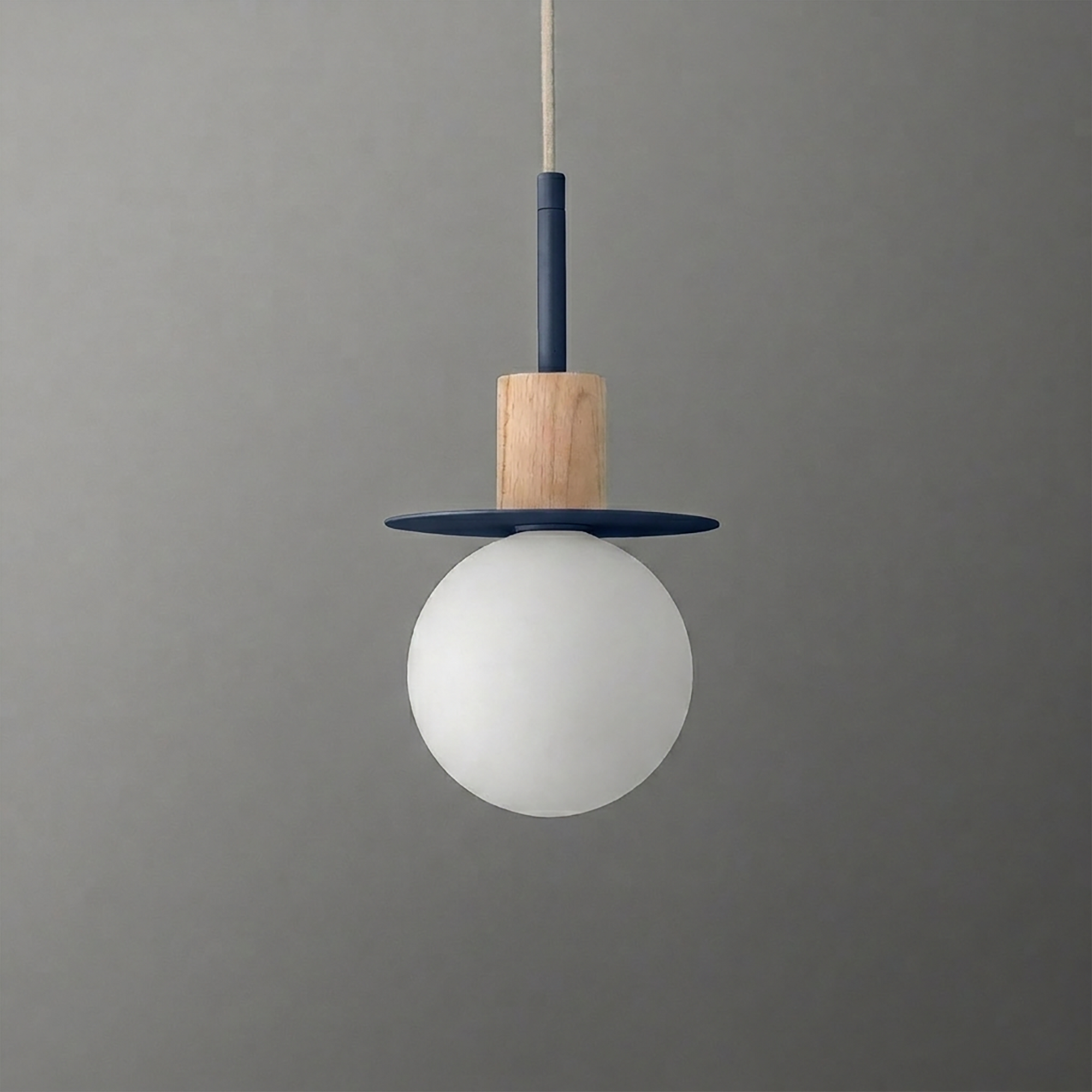 Pendant light with frosted white globe, wooden accent, and navy blue circular metal detail hanging from a beige cord. - PENDANT MODEL NO. 6198
