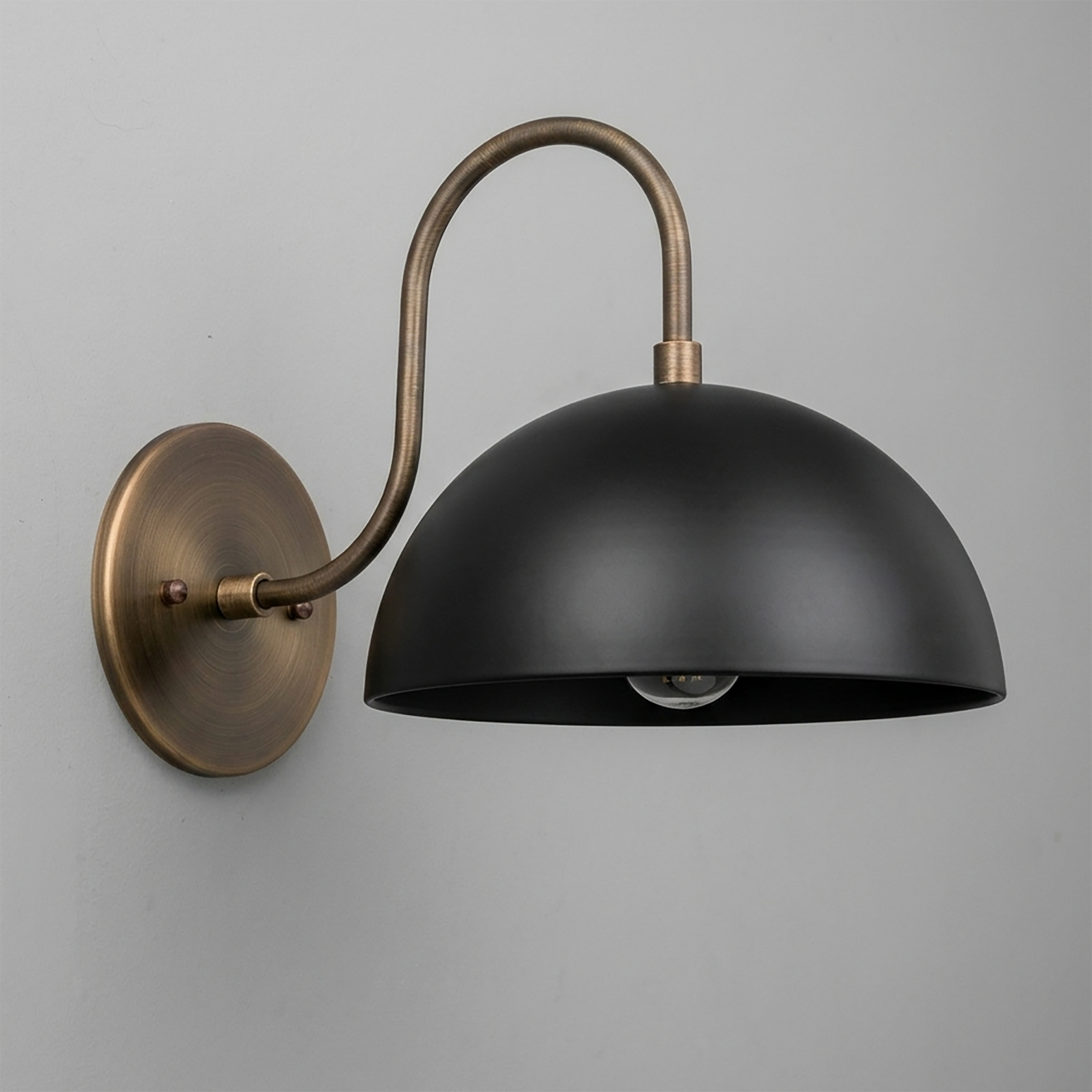 Black dome-shaped metal sconce with antique brass curved arm and round wall mount. - SCONCE MODEL NO. 9092