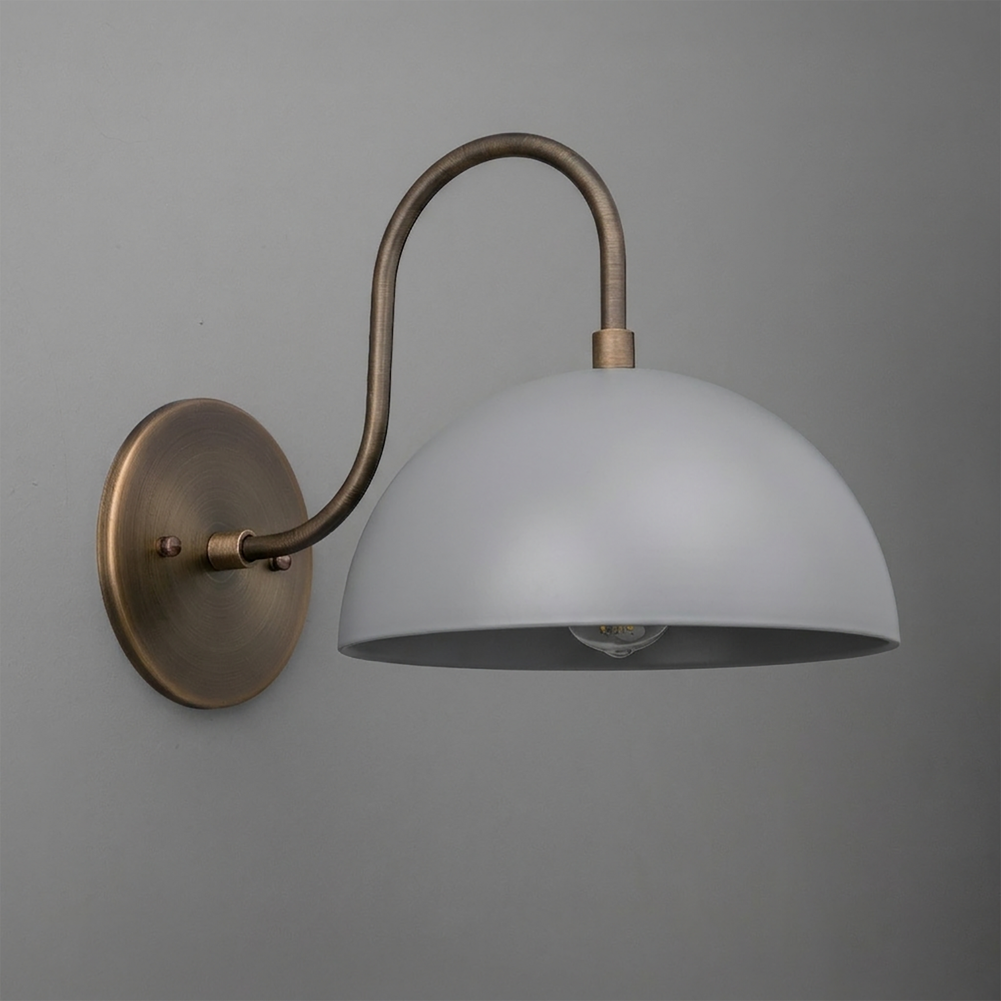 Wall-mounted single-bulb sconce with antique brass curved arm and matte white dome shade. - SCONCE MODEL NO. 9092