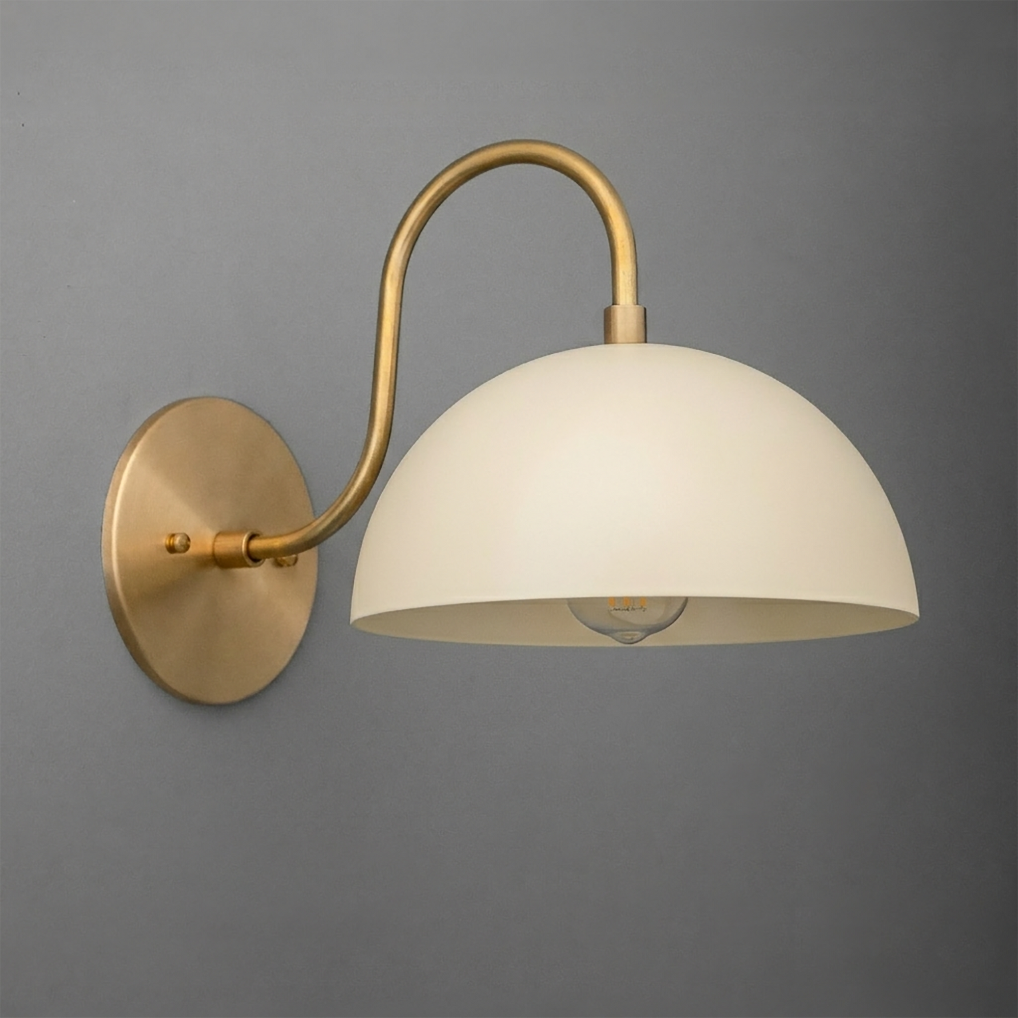 Matte white dome-shaped glass shade with a curved brass arm and round brass wall mount sconce. - SCONCE MODEL NO. 9092