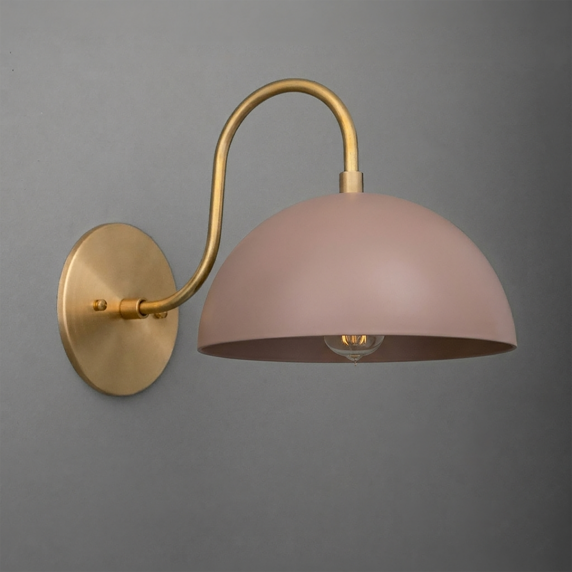 Matte brass wall sconce with curved arm and mauve dome-shaped shade, single bulb design. - SCONCE MODEL NO. 9092