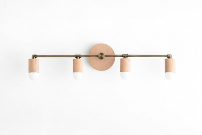 Four-light vanity fixture with natural wood accents and cylindrical white shades on a horizontal brass bar. - VANITY LIGHT MODEL NO. 2017