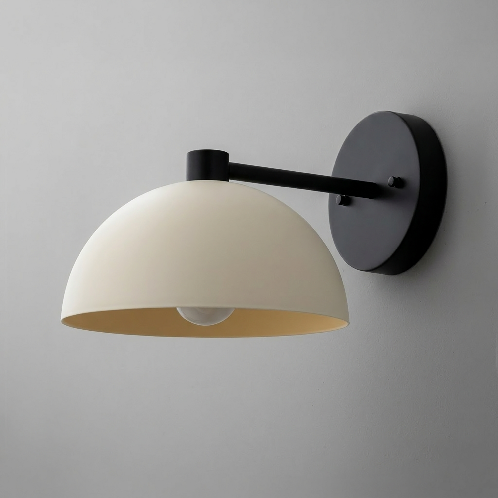Black metal wall sconce with a dome-shaped matte white glass shade and a single exposed bulb. - SCONCE MODEL NO. 2946