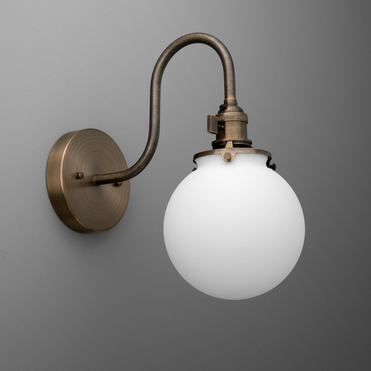 Wall-mounted sconce with antique brass finish and frosted white glass globe shade. - SCONCE MODEL NO. 0017