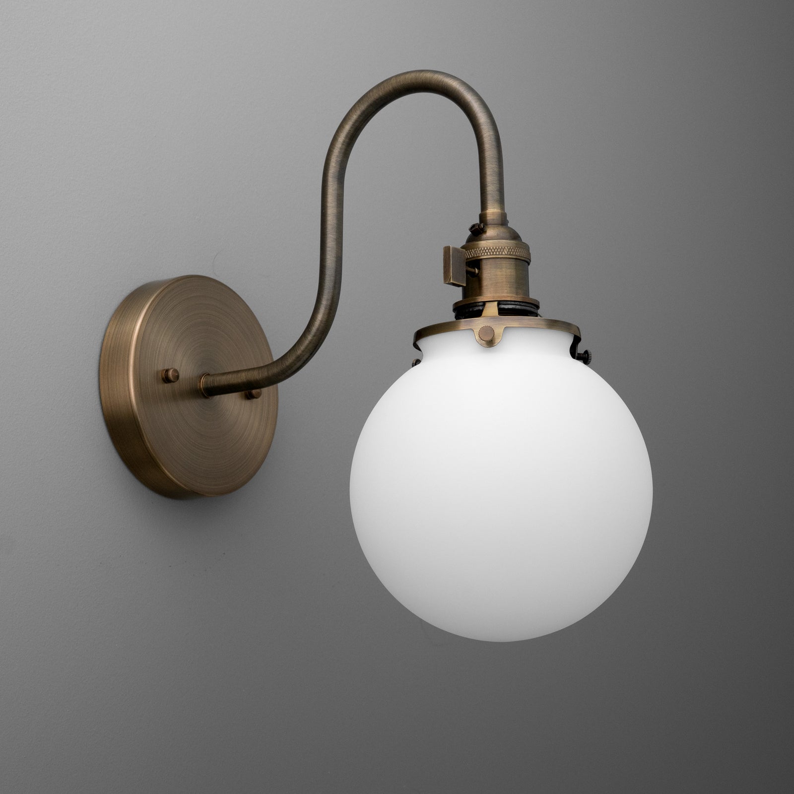Wall-mounted sconce with antique brass finish and frosted white glass globe shade. - SCONCE MODEL NO. 0017