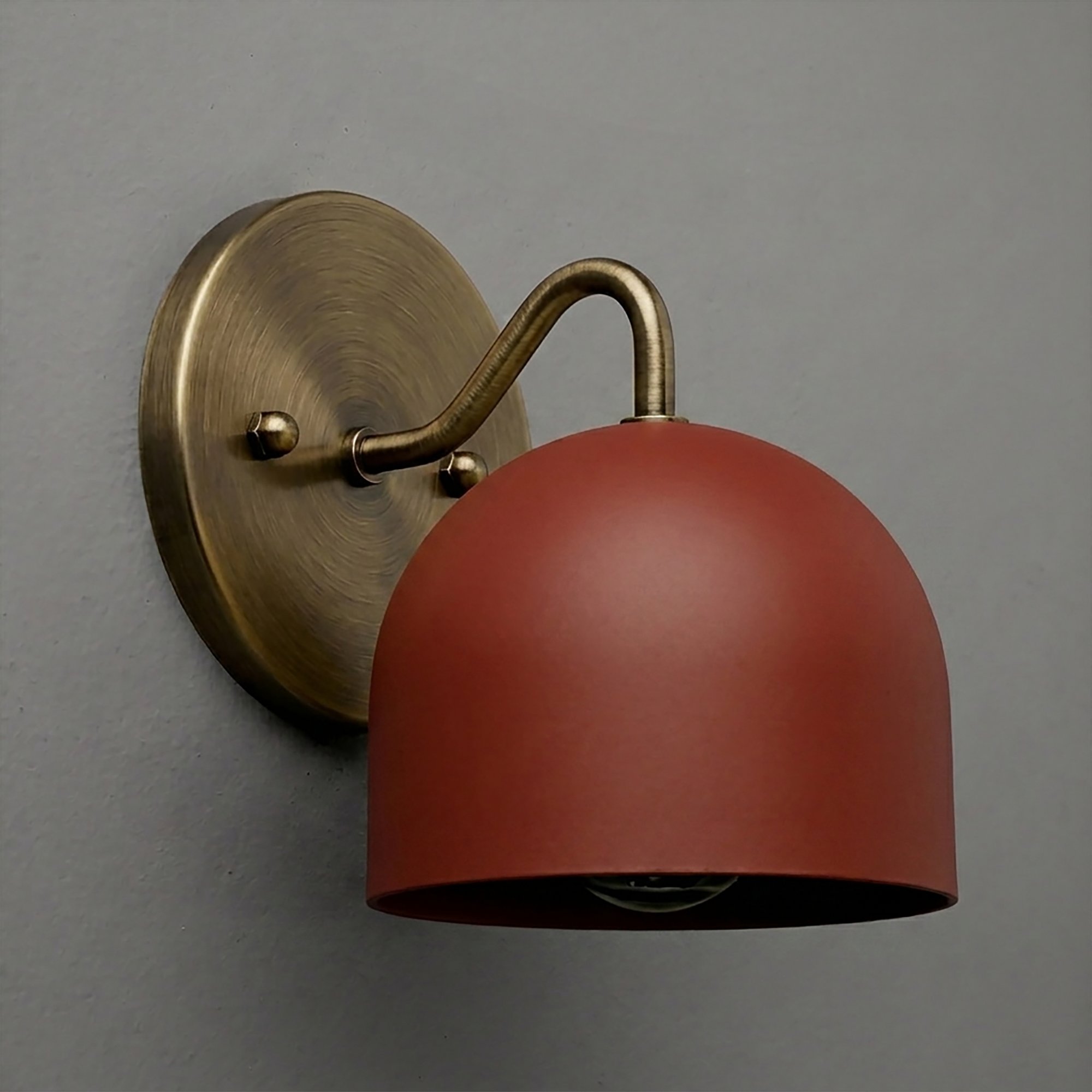 Wall sconce with matte terracotta dome shade and antique brass curved arm and round backplate. - SCONCE MODEL NO. 9436