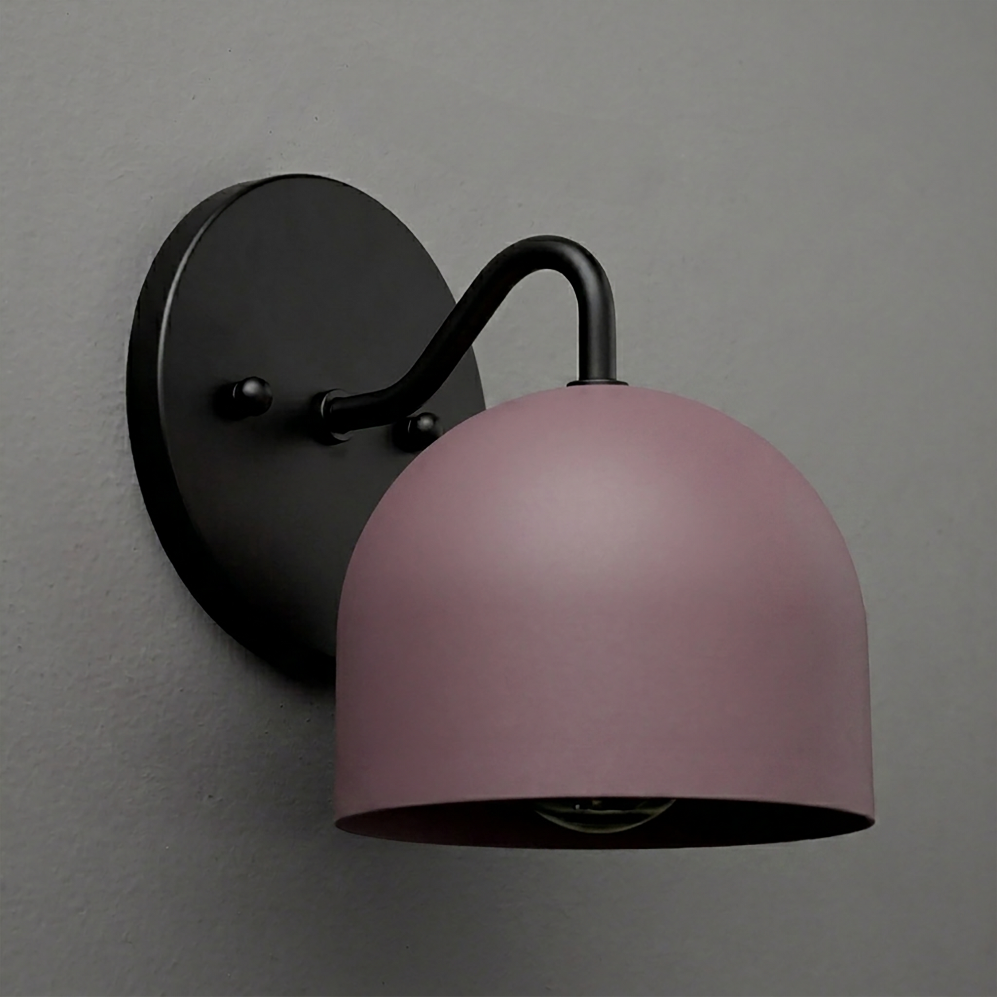 Black metal wall sconce with curved arm and matte pink dome-shaped shade, single bulb design. - SCONCE MODEL NO. 9436