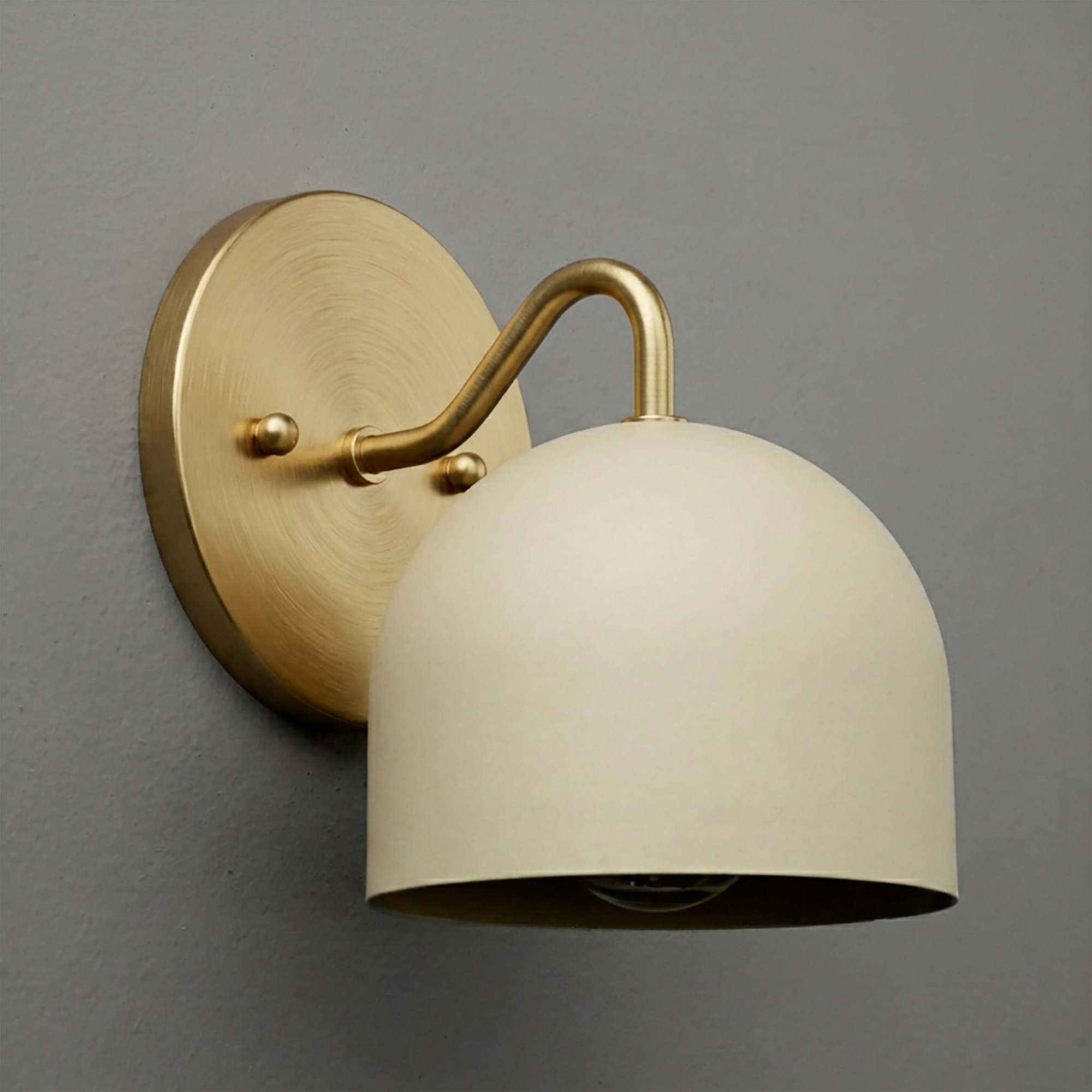 Brushed brass wall sconce with curved arm and matte cream dome-shaped metal shade. - SCONCE MODEL NO. 9436
