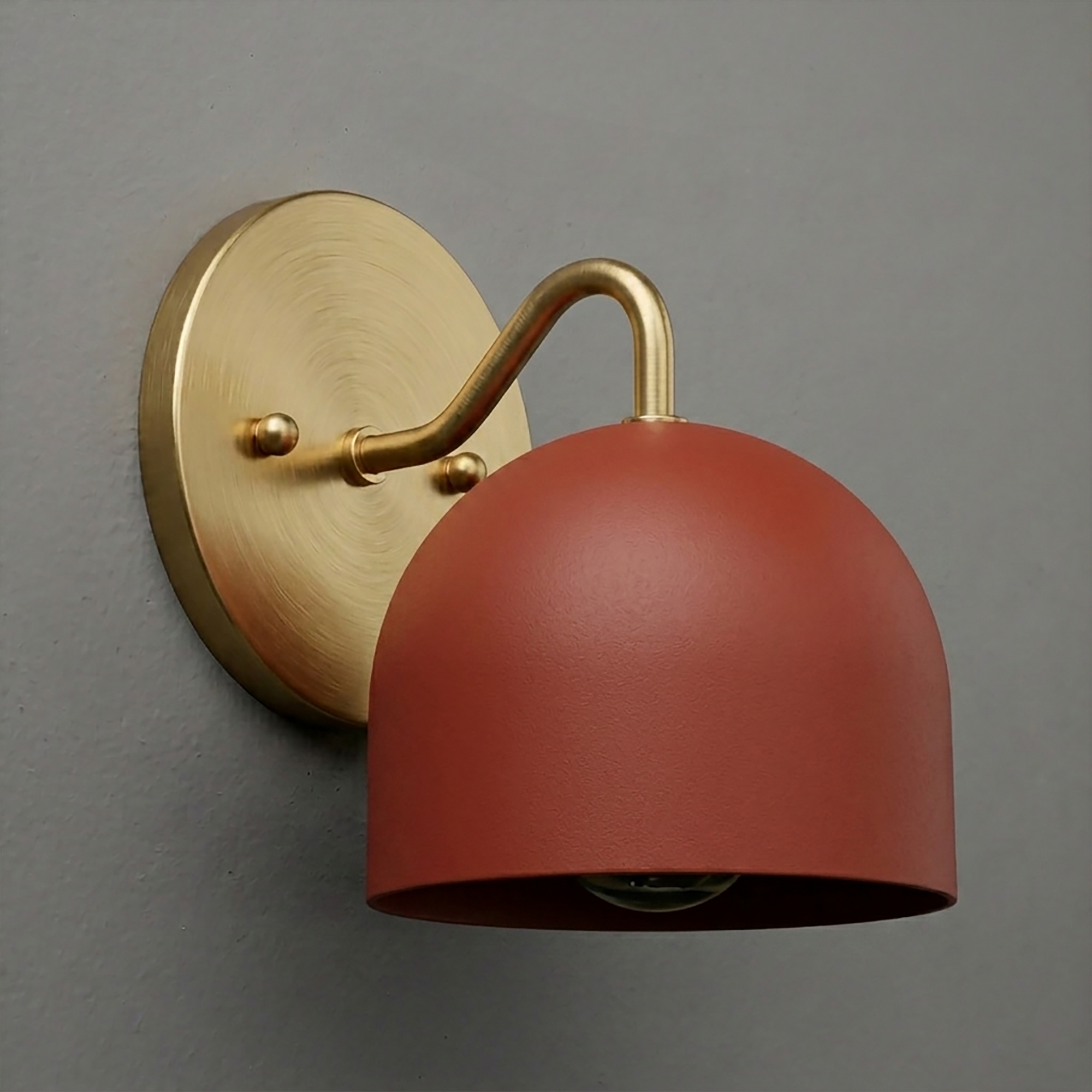 Matte rust red dome-shaped metal shade with brushed brass curved arm and round wall mount sconce. - SCONCE MODEL NO. 9436