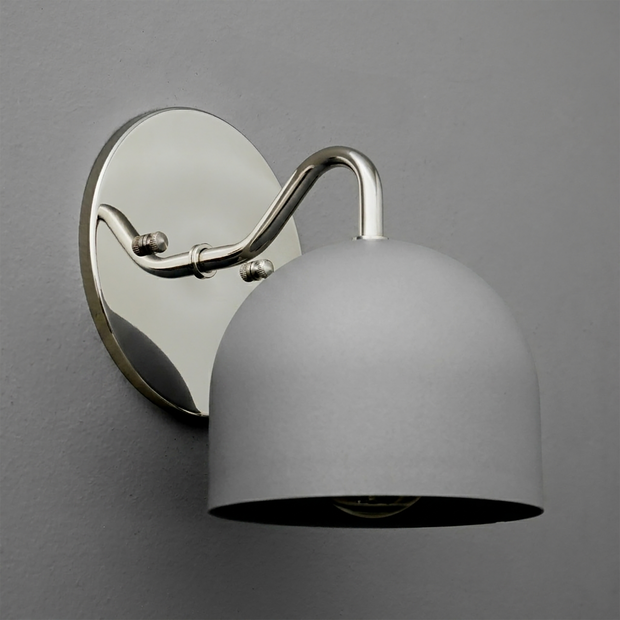Matte silver metal sconce with dome-shaped shade and curved arm mounted on oval backplate. - SCONCE MODEL NO. 9436