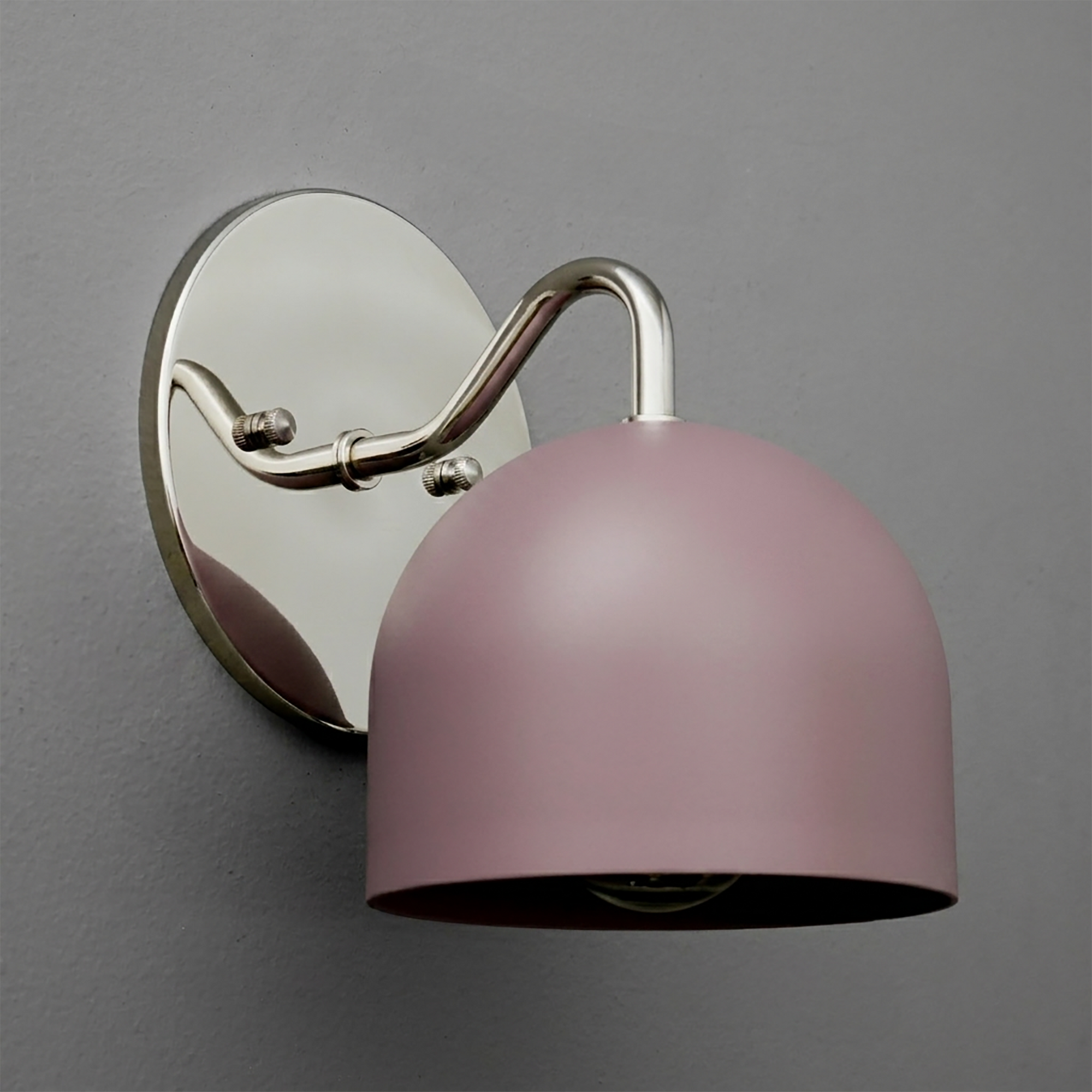 Wall sconce with matte pink dome-shaped metal shade and curved silver arm on oval silver backplate. - SCONCE MODEL NO. 9436
