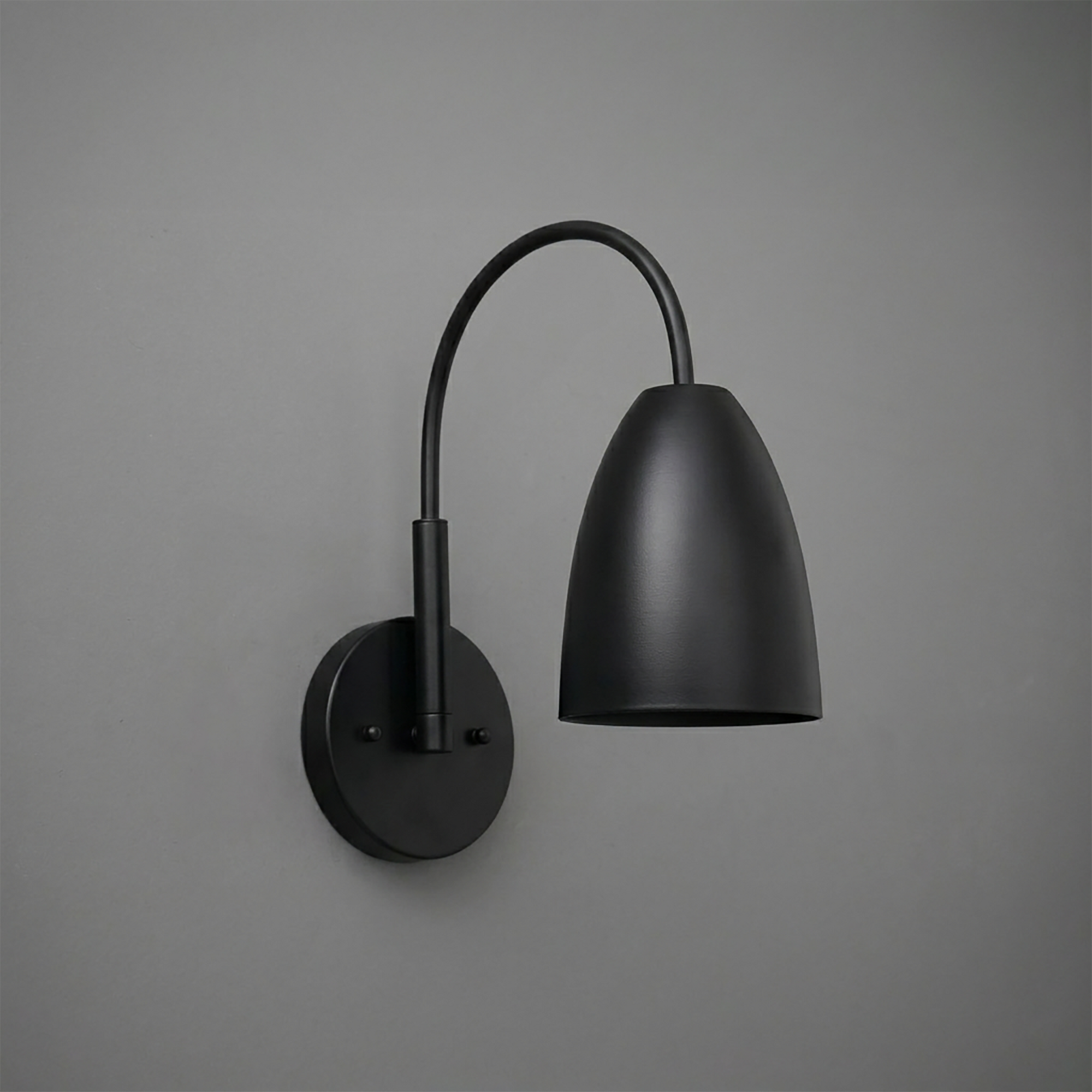 Matte black metal wall sconce with curved arm and tapered cylindrical shade. - SCONCE MODEL NO. 2977