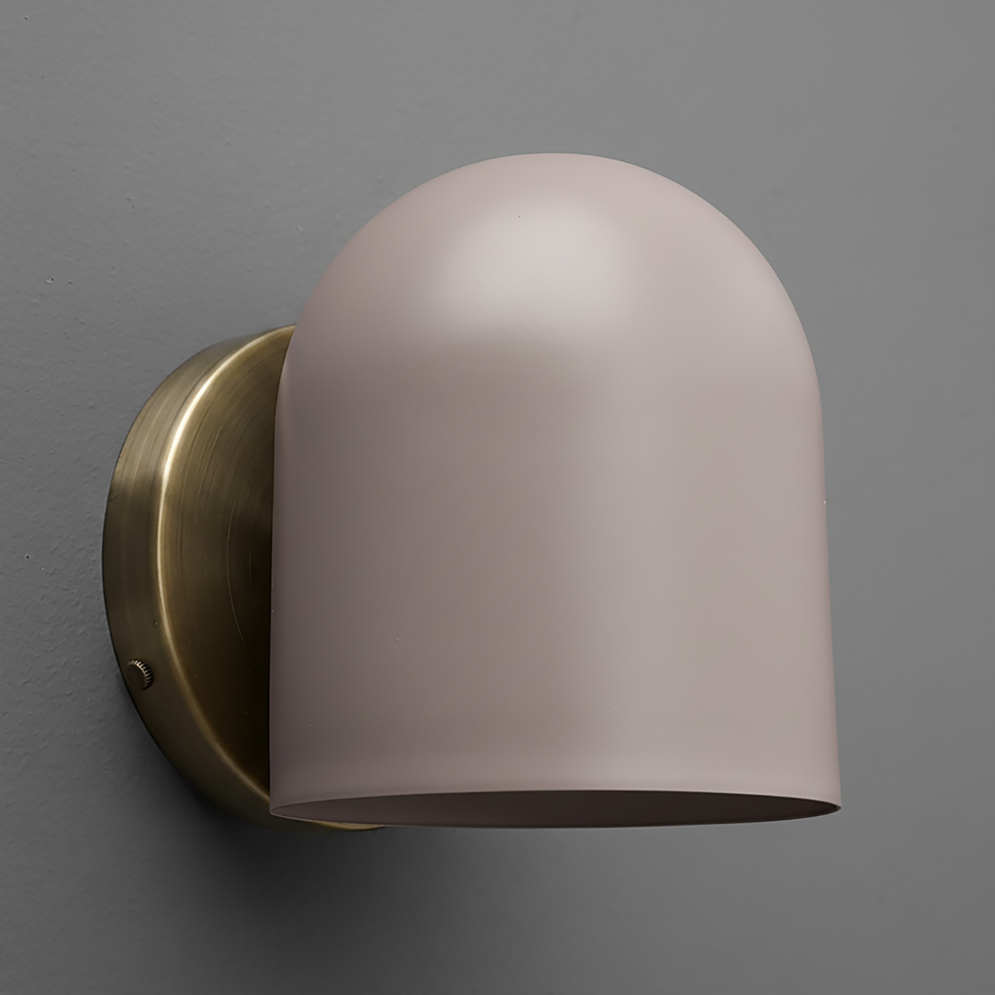 Wall sconce with matte light pink dome shade and brushed brass round mounting plate. - SCONCE MODEL NO. 2424