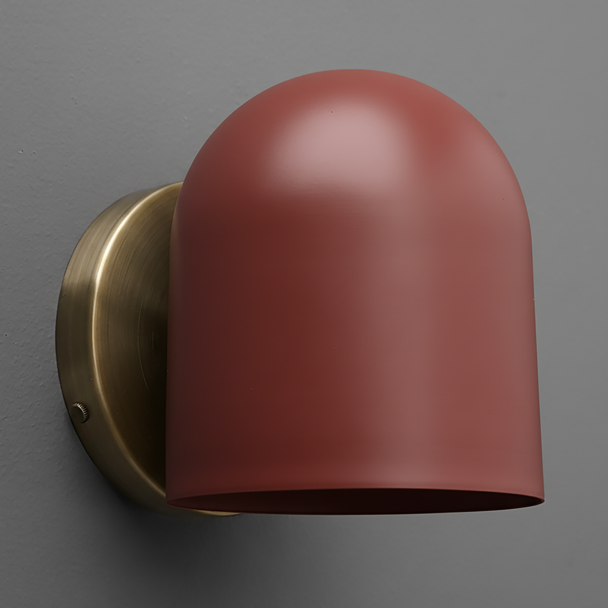 Matte terracotta dome-shaped metal sconce with antique brass oval mounting plate on gray wall. - SCONCE MODEL NO. 2424