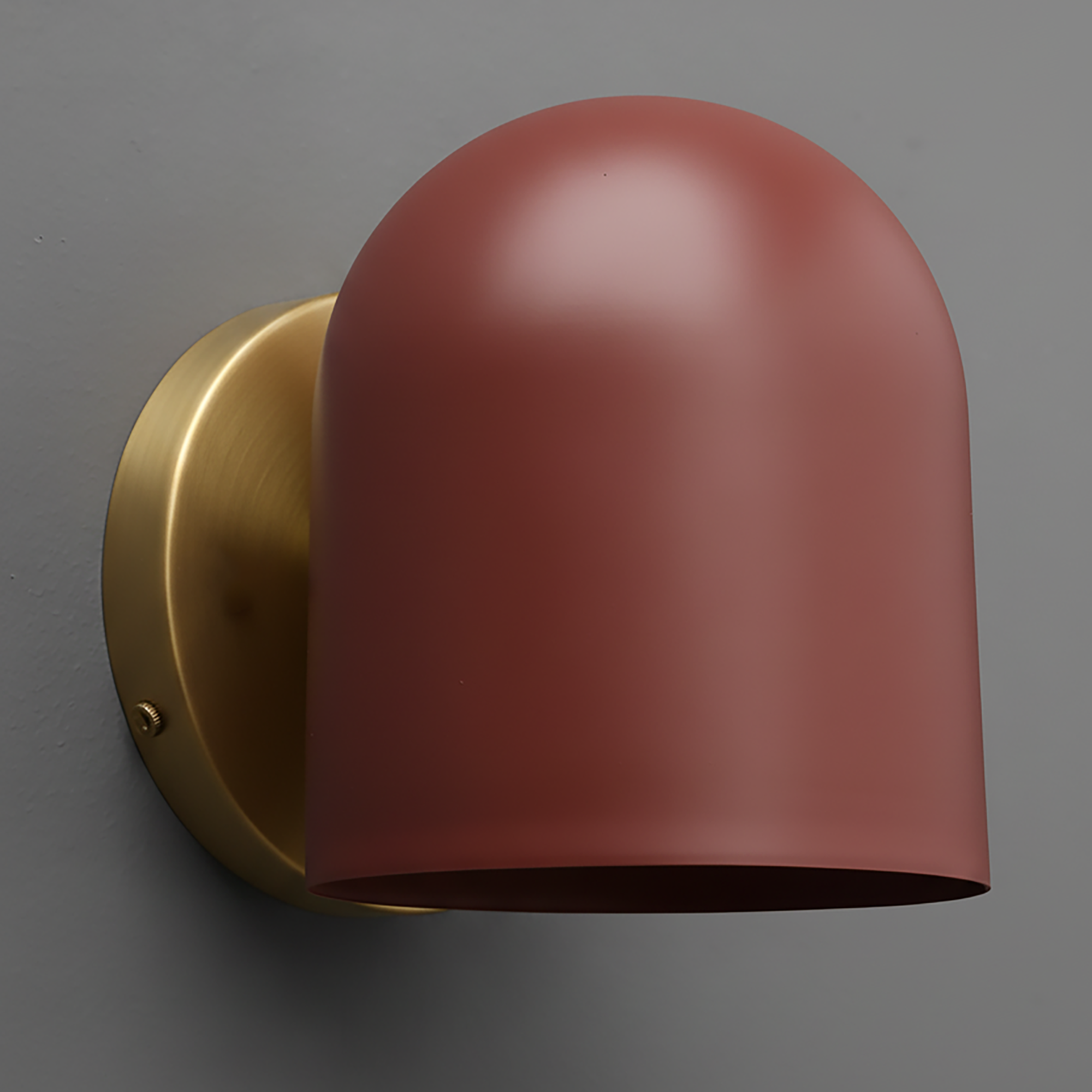 Wall sconce with domed brick red metal shade and antique brass round base mounted on gray wall. - SCONCE MODEL NO. 2424