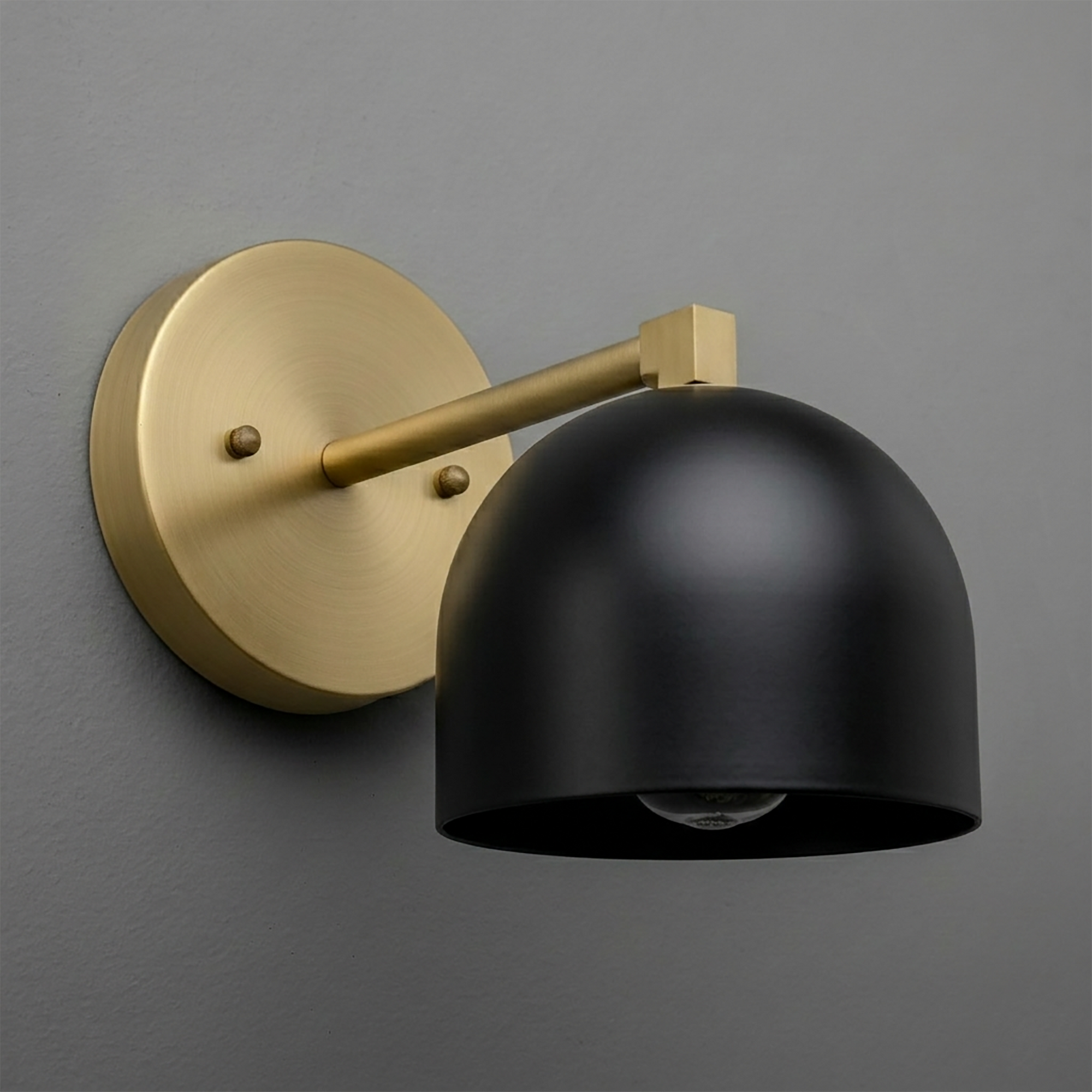 Black matte dome shade sconce with brass round base and arm mount on gray wall. - SCONCE MODEL NO. 3622