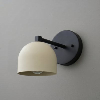 Black metal wall sconce with a matte cream dome-shaped shade and exposed bulb design. - SCONCE MODEL NO. 3622