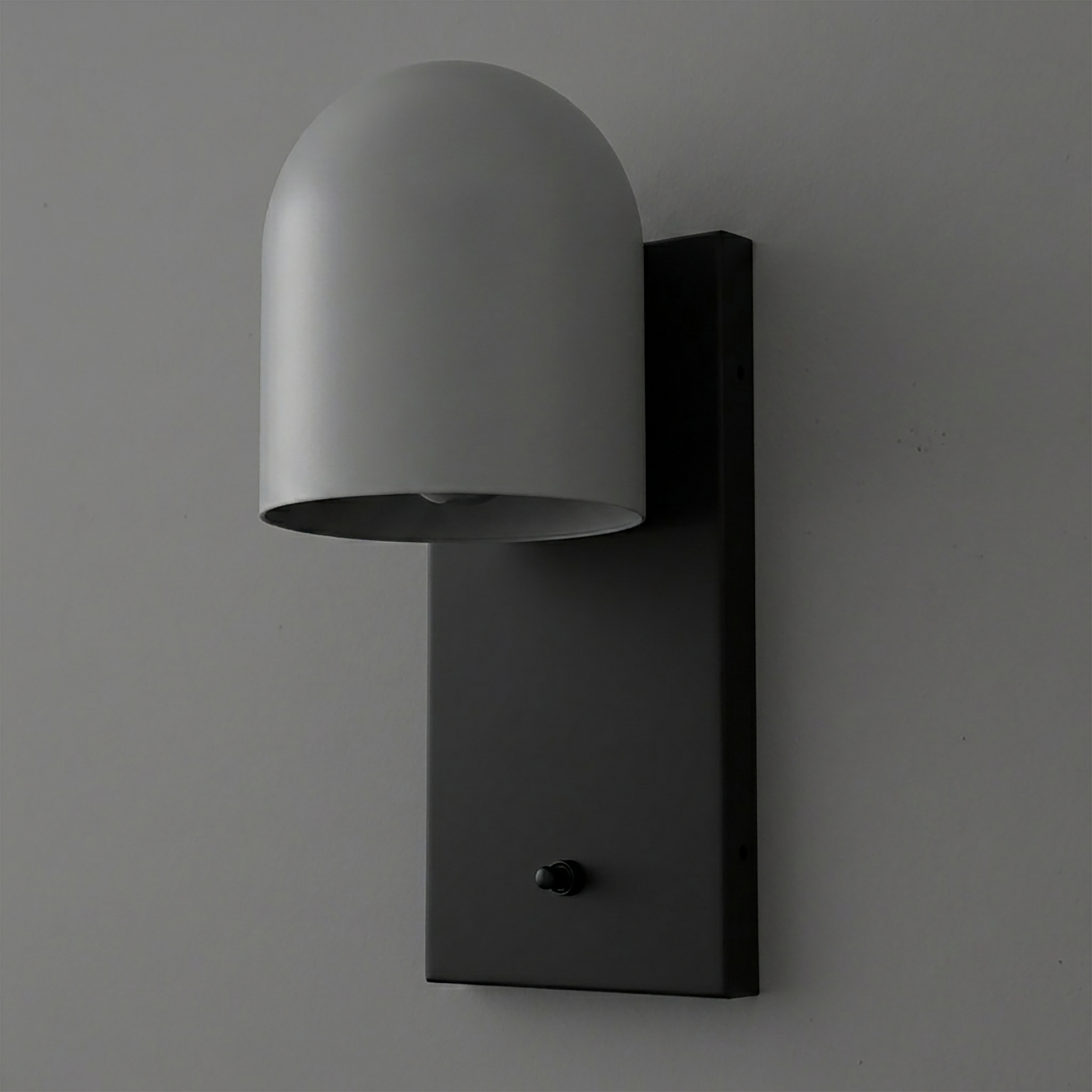 Matte black rectangular metal wall mount with a curved, dome-shaped gray metal shade and a small black switch. - SCONCE MODEL NO. 6029
