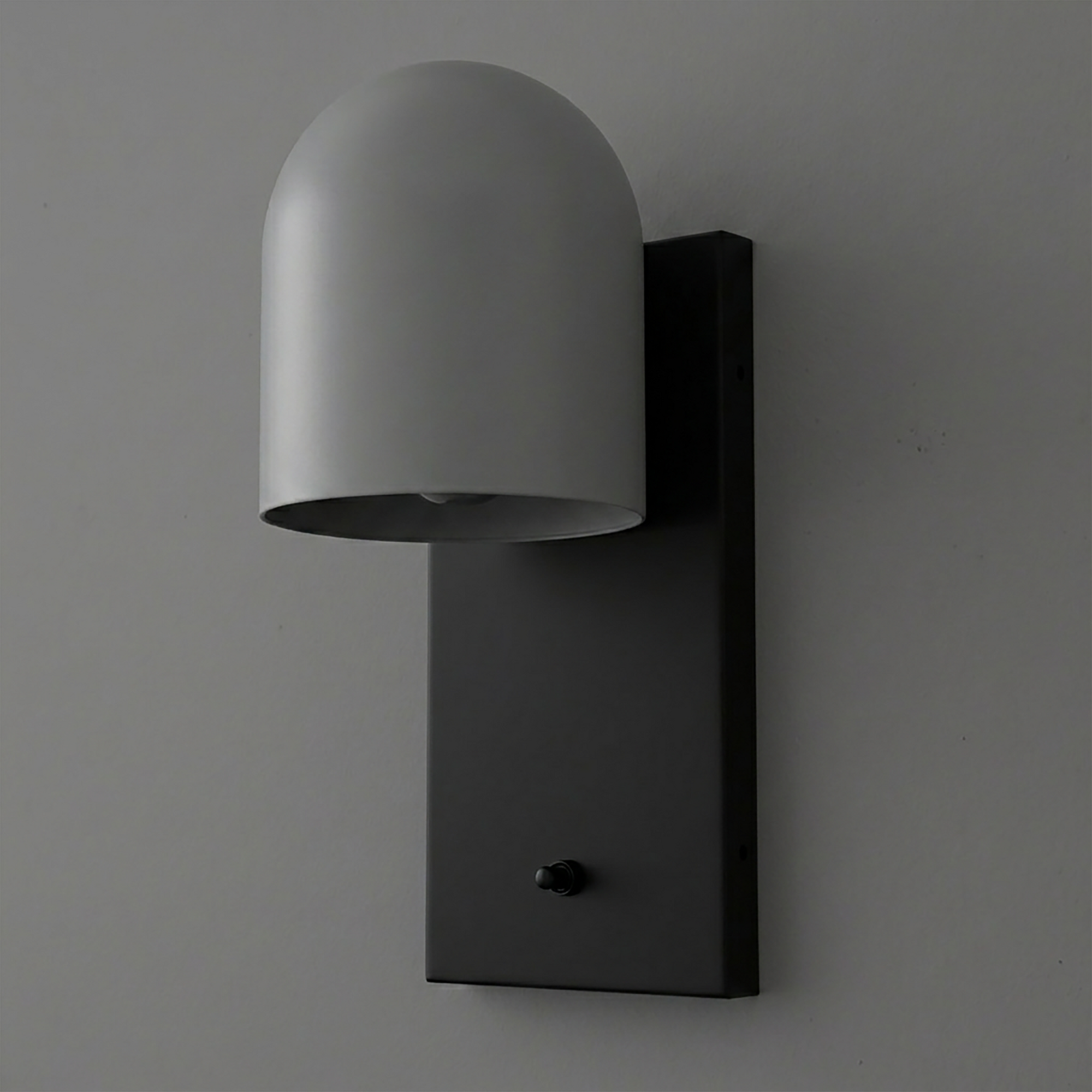 Matte black rectangular metal wall mount with a curved, dome-shaped gray metal shade and a small black switch. - SCONCE MODEL NO. 6029
