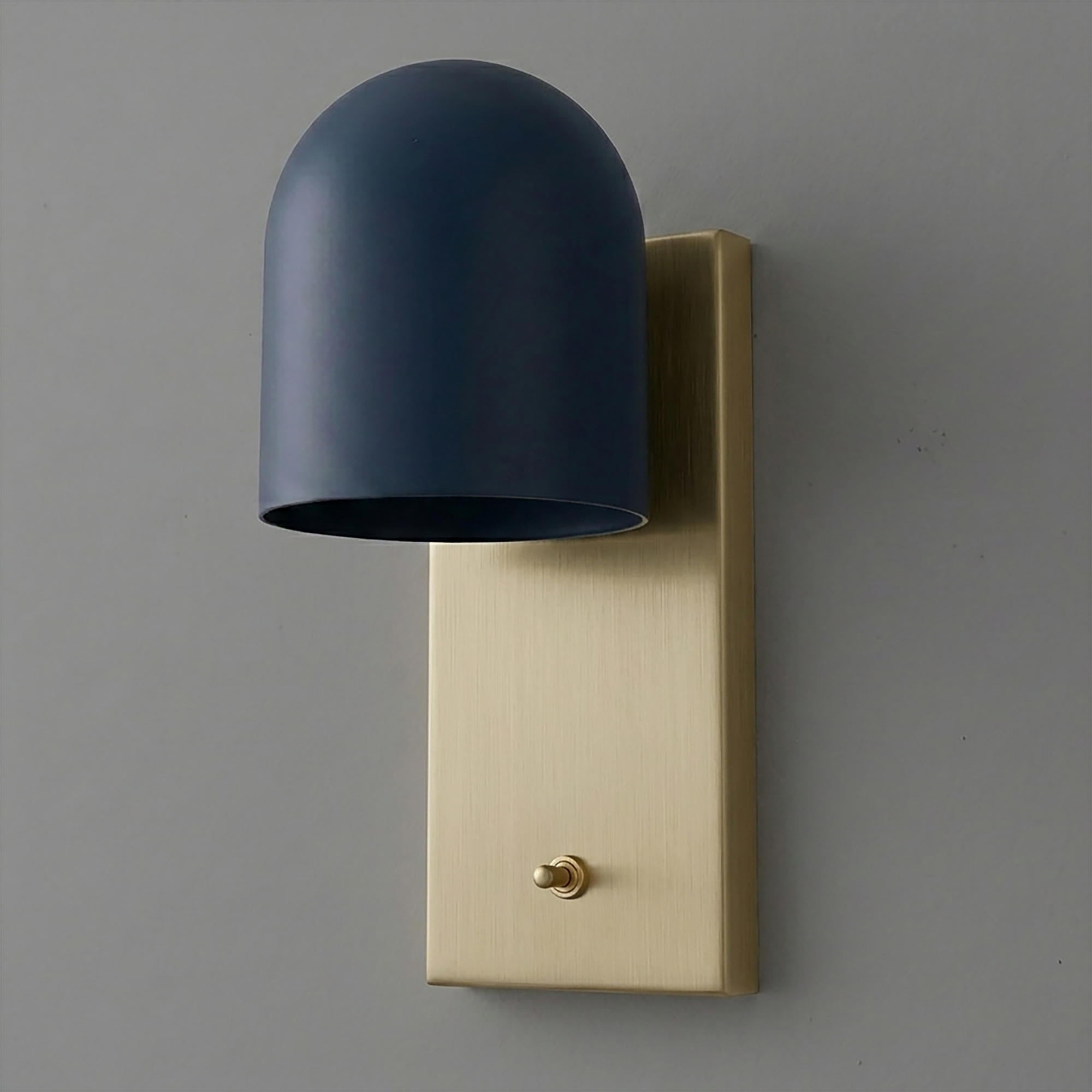 Wall sconce with matte black dome shade and brushed brass rectangular backplate with toggle switch. - SCONCE MODEL NO. 6029