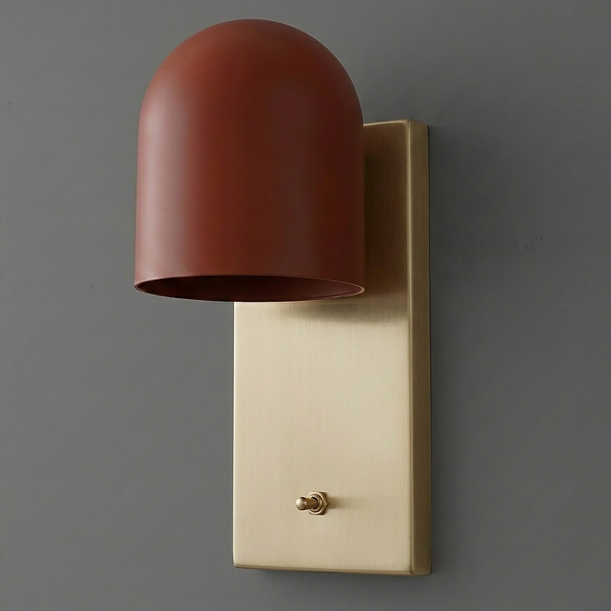 Wall sconce with matte rust-colored dome shade and rectangular brushed brass backplate with toggle switch. - SCONCE MODEL NO. 6029