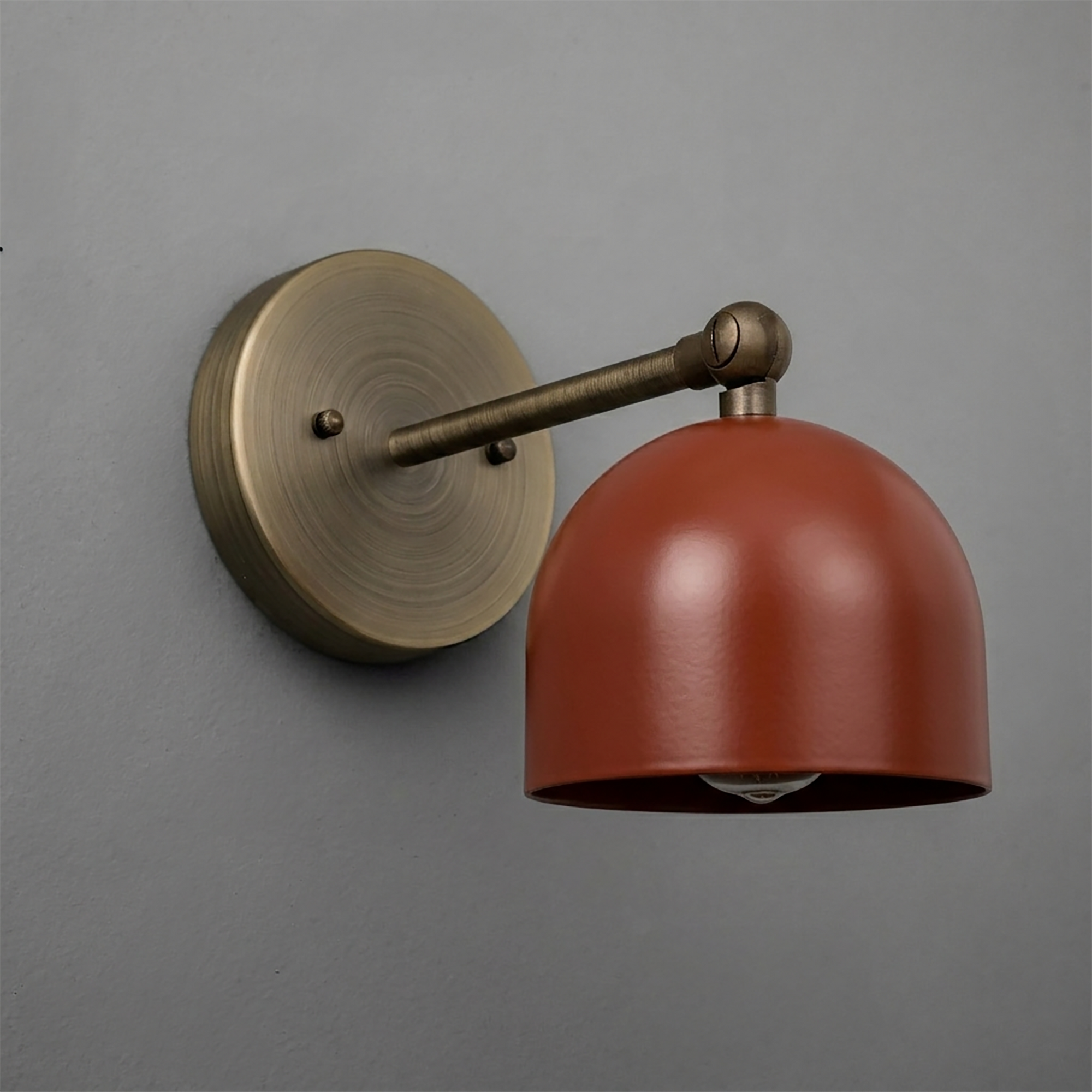 Wall-mounted sconce with an antique brass finish and a smooth, dome-shaped matte rust-colored shade. - SCONCE MODEL NO. 5103