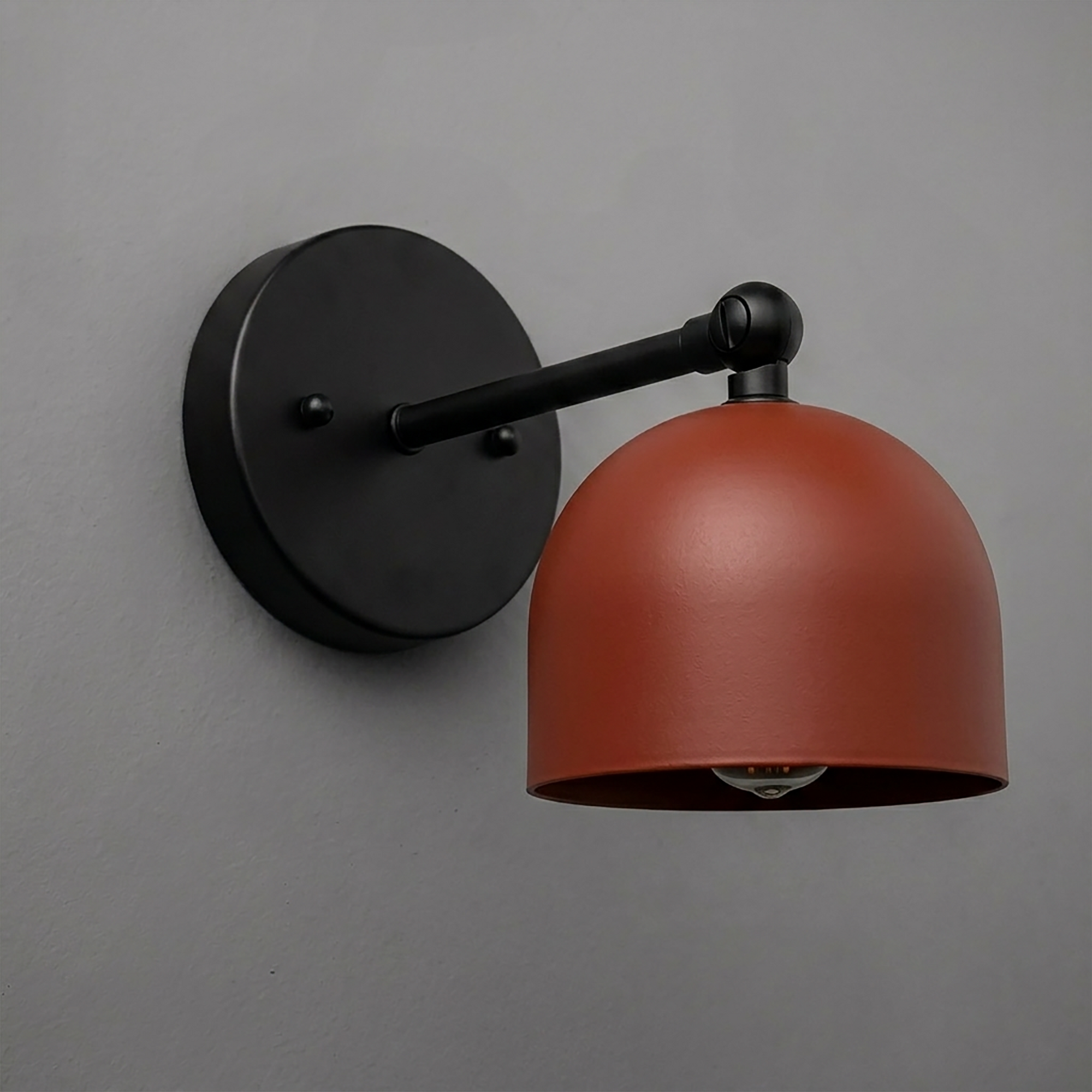Wall-mounted sconce with a matte black round base and arm, featuring a rust-colored dome-shaped metal shade. - SCONCE MODEL NO. 5103