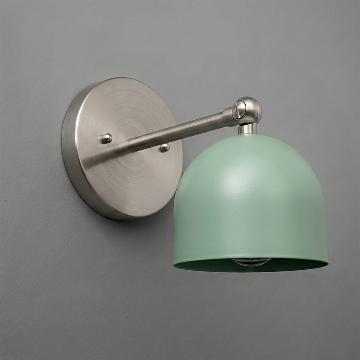 Matte silver metal wall sconce with round base and adjustable arm, featuring a smooth pastel green dome-shaped shade. - SCONCE MODEL NO. 5103