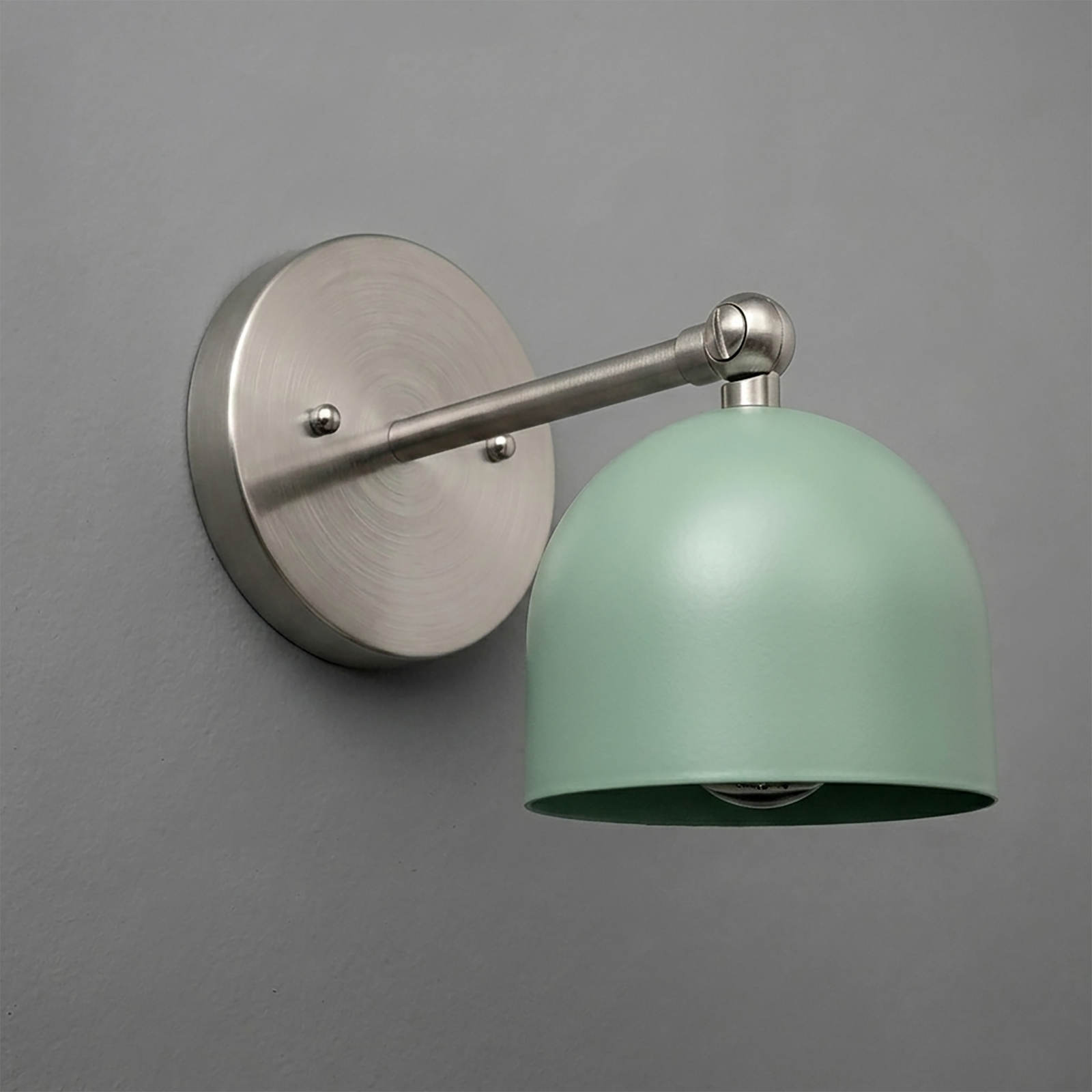 Matte silver metal wall sconce with round base and adjustable arm, featuring a smooth pastel green dome-shaped shade. - SCONCE MODEL NO. 5103