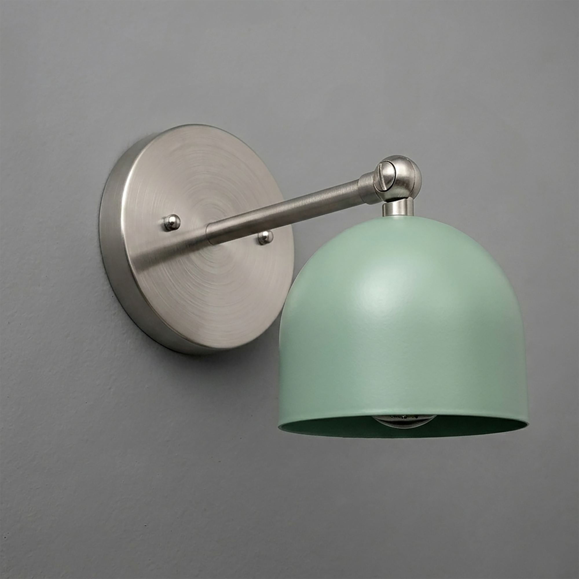 Matte silver metal wall sconce with round base and adjustable arm, featuring a smooth pastel green dome-shaped shade. - SCONCE MODEL NO. 5103