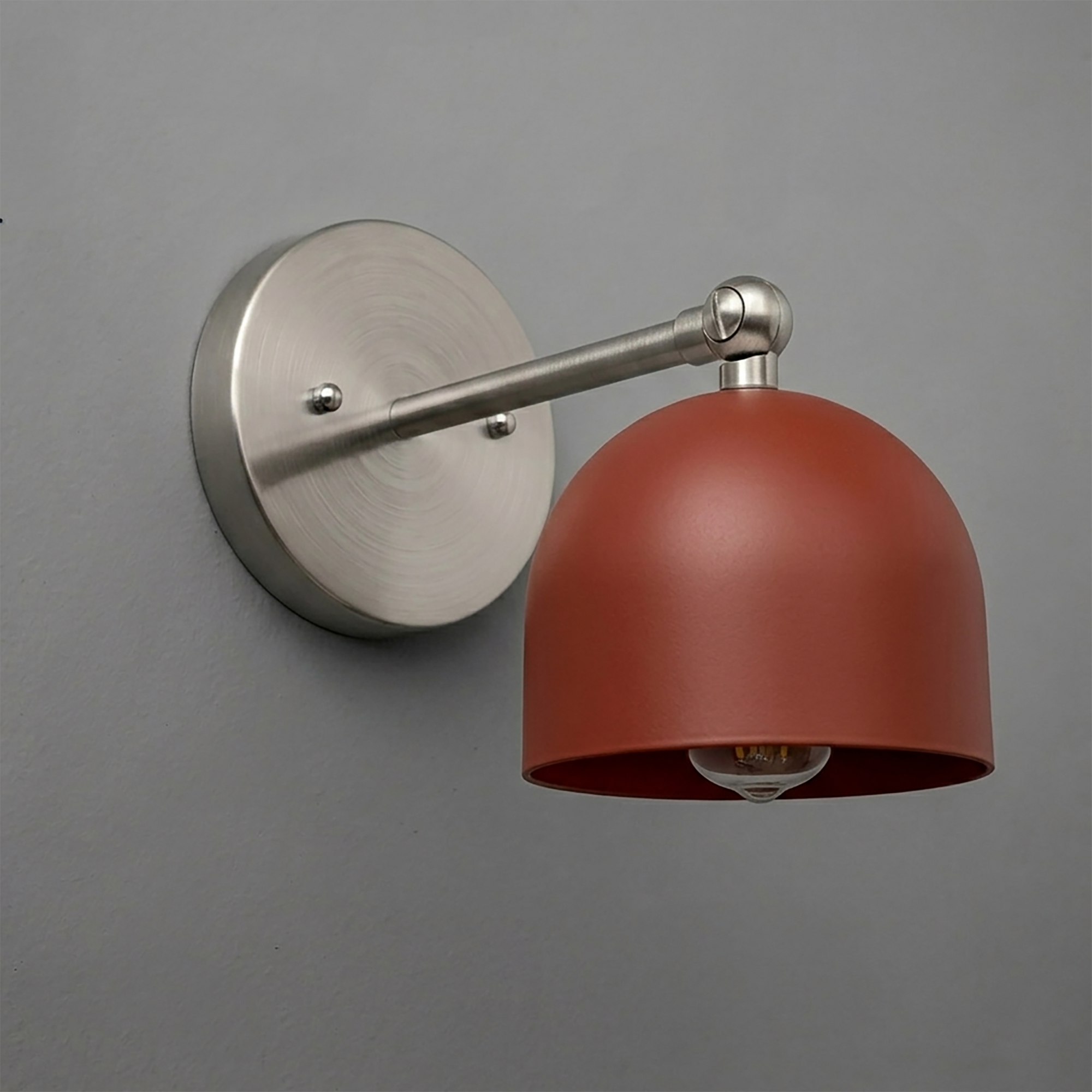 Wall-mounted sconce with brushed nickel circular base and arm, featuring a matte rust red dome-shaped metal shade. - SCONCE MODEL NO. 5103