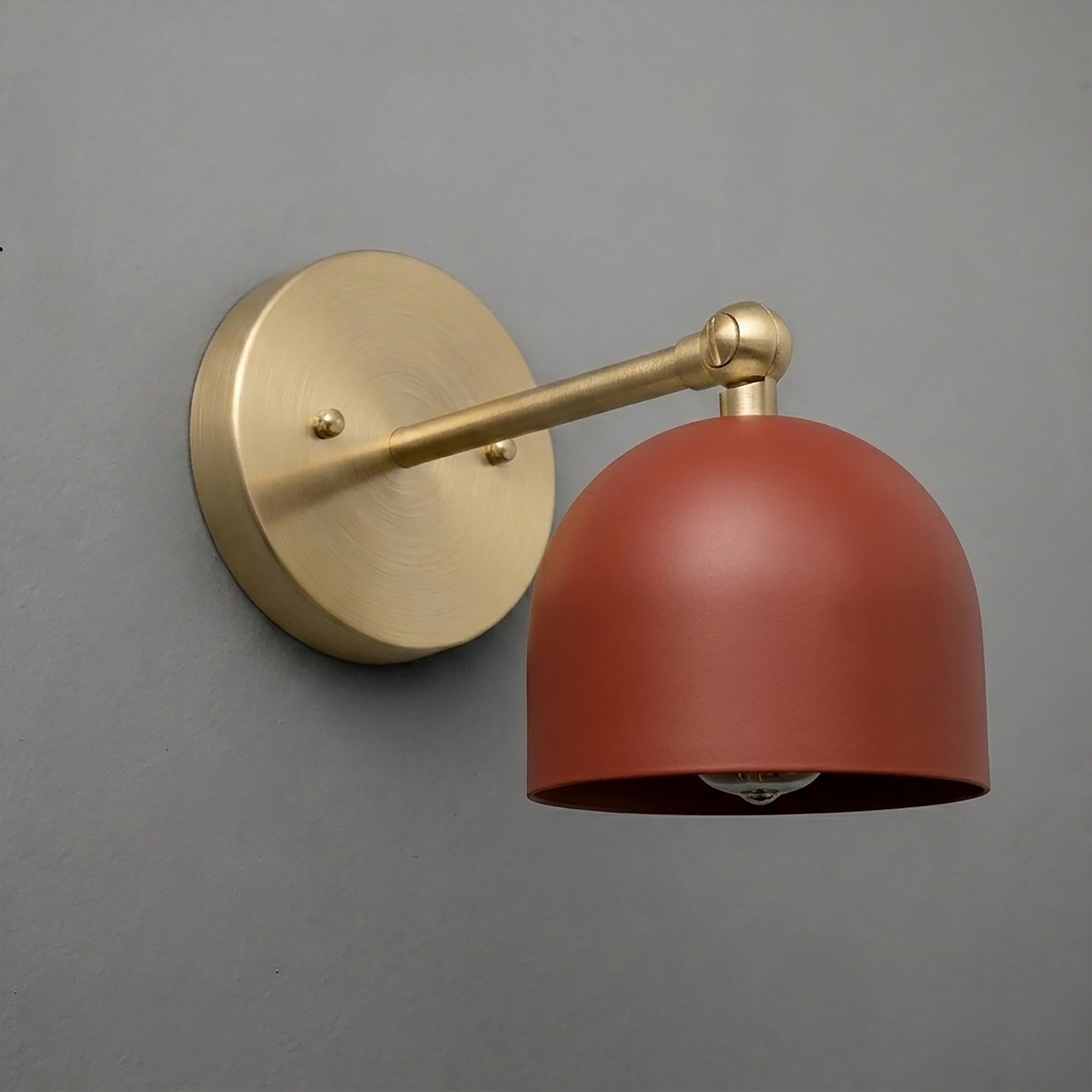 Wall sconce with matte brass round base and arm, featuring a rust-colored dome-shaped metal shade. - SCONCE MODEL NO. 5103